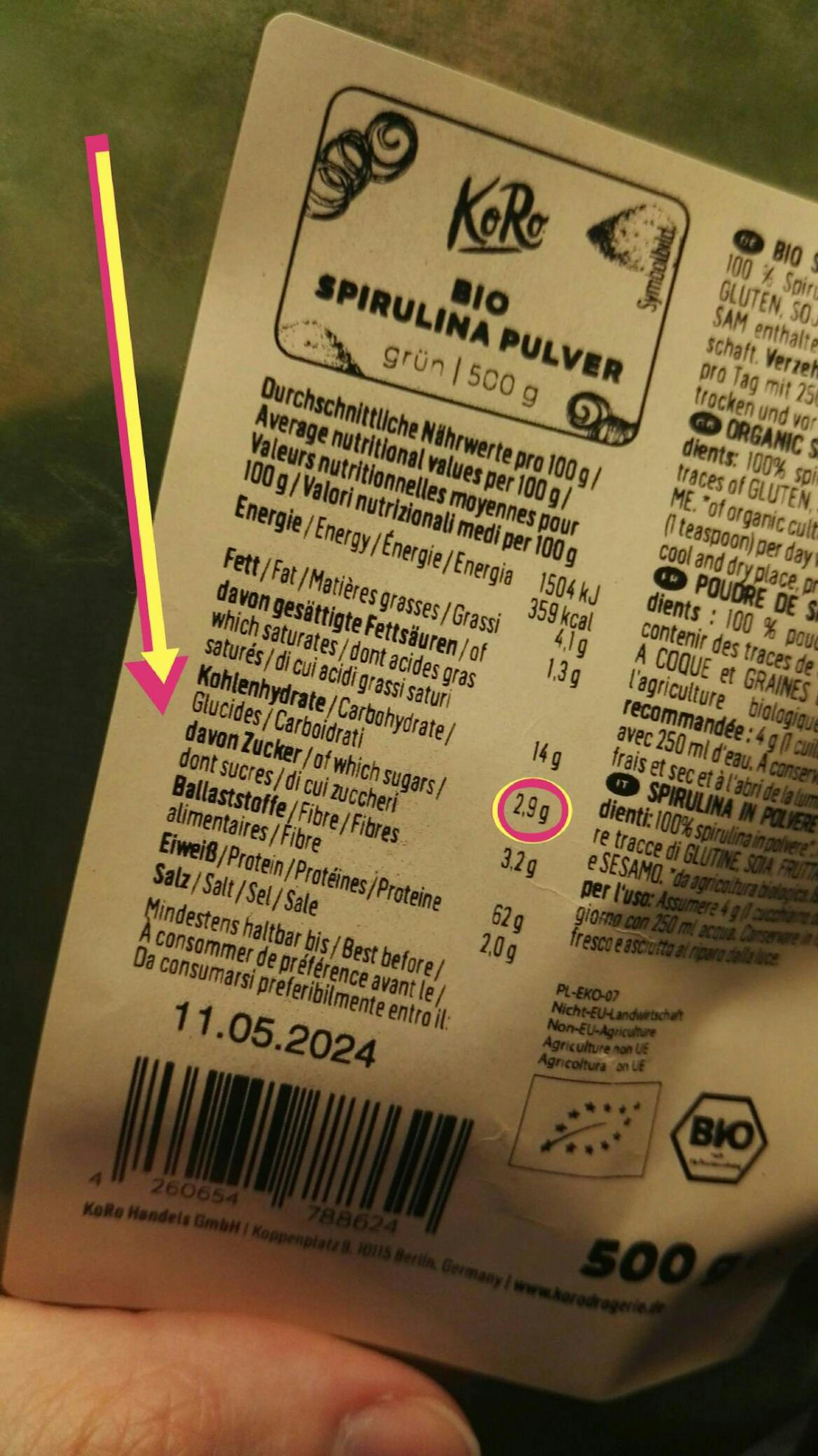 eine Person hält ein Etikett mit der Aufschrift bio spirulina pulver