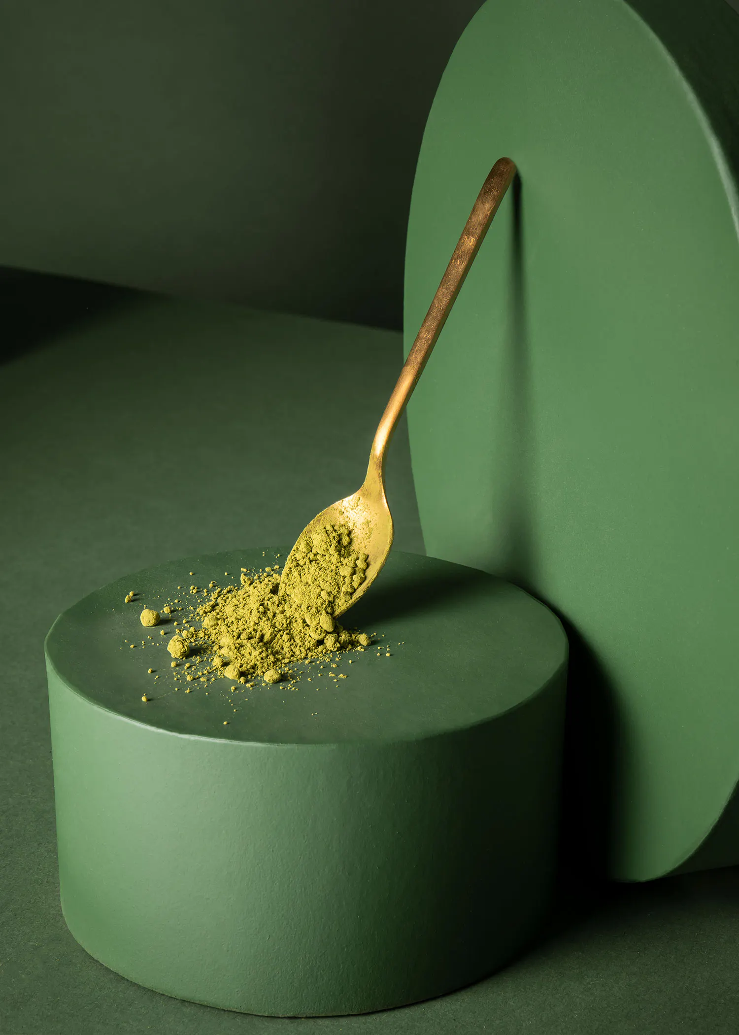 ein goldener Löffel hält einen Haufen grünesPulver