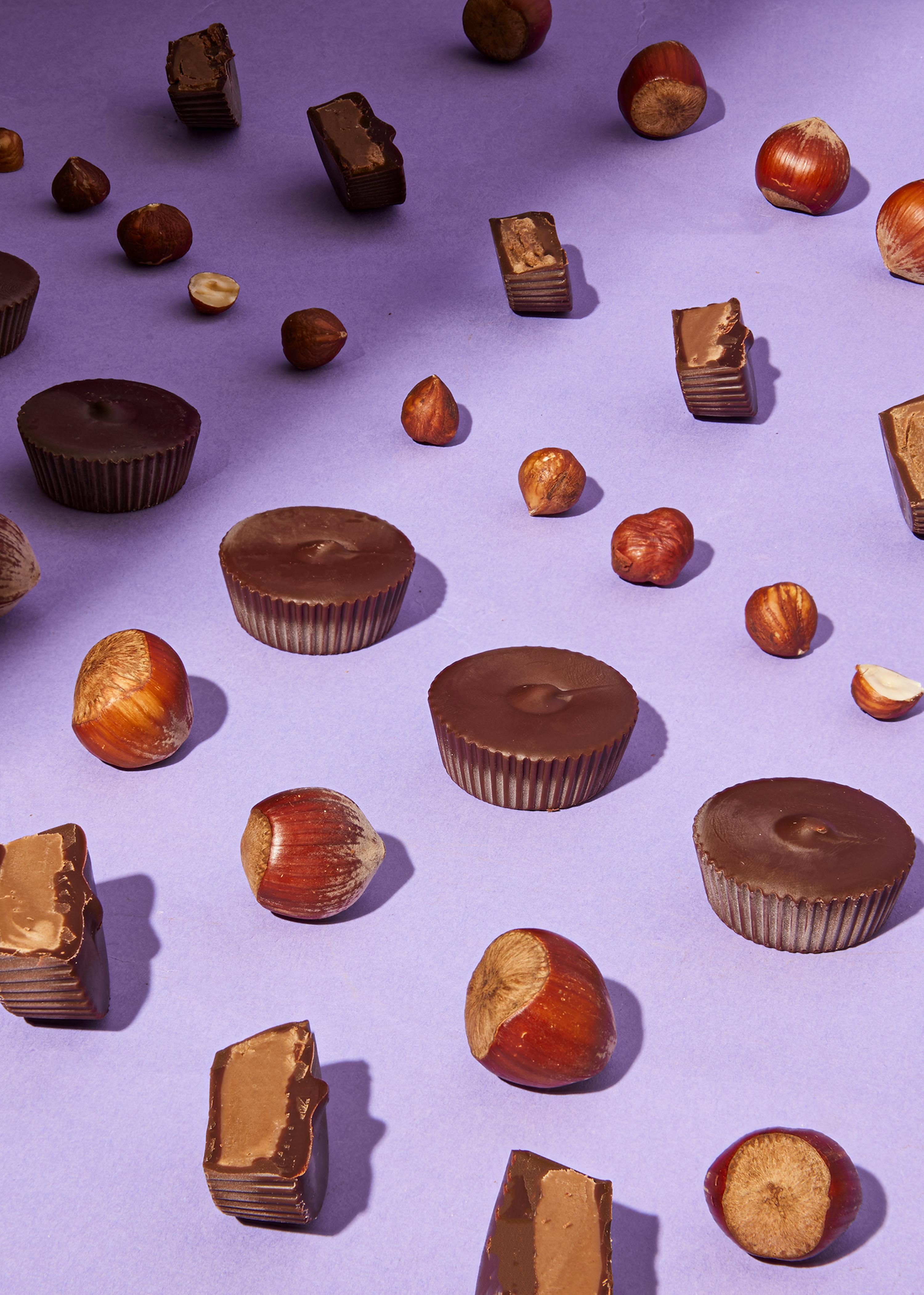 a variety of chocolates and nuts on a purple background