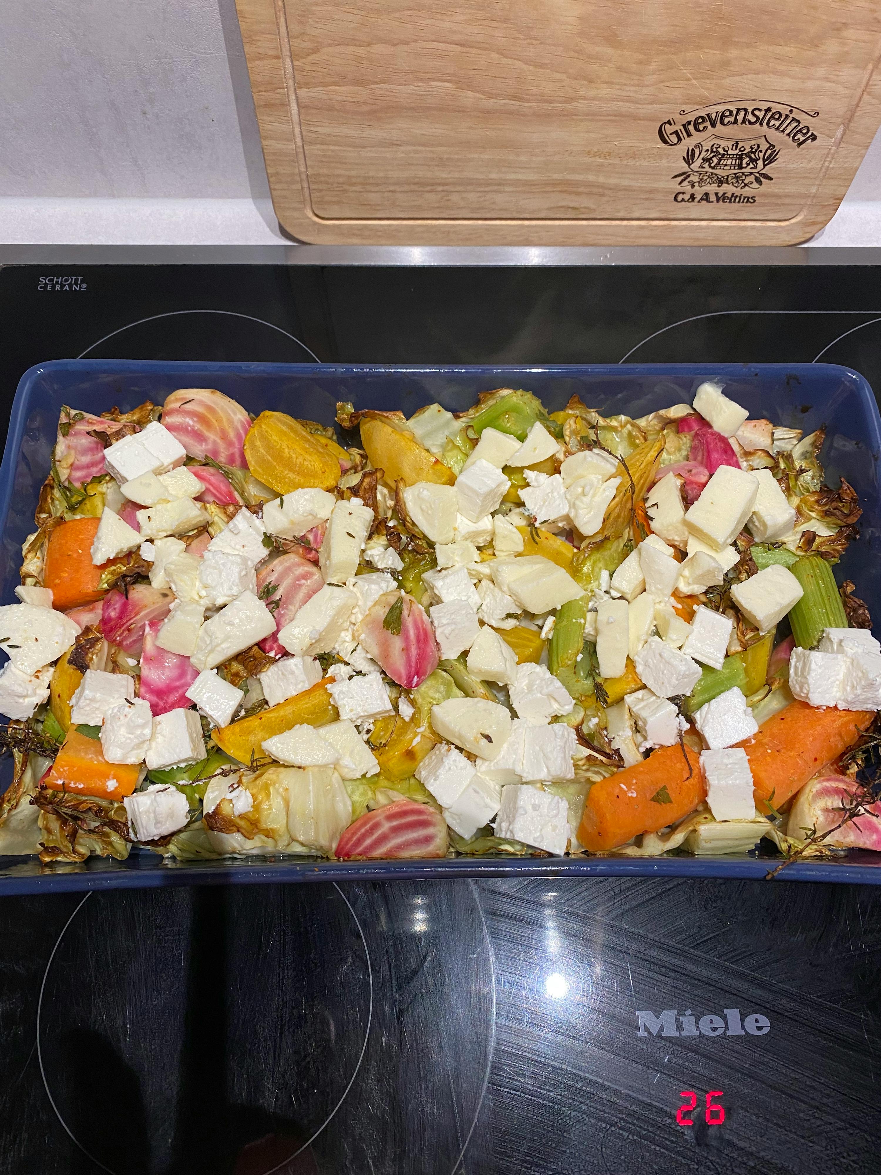 eine Schüssel mit Gemüse und Käse steht auf einem Herd neben einem Schneidebrett mit der Aufschrift " crever & staller "