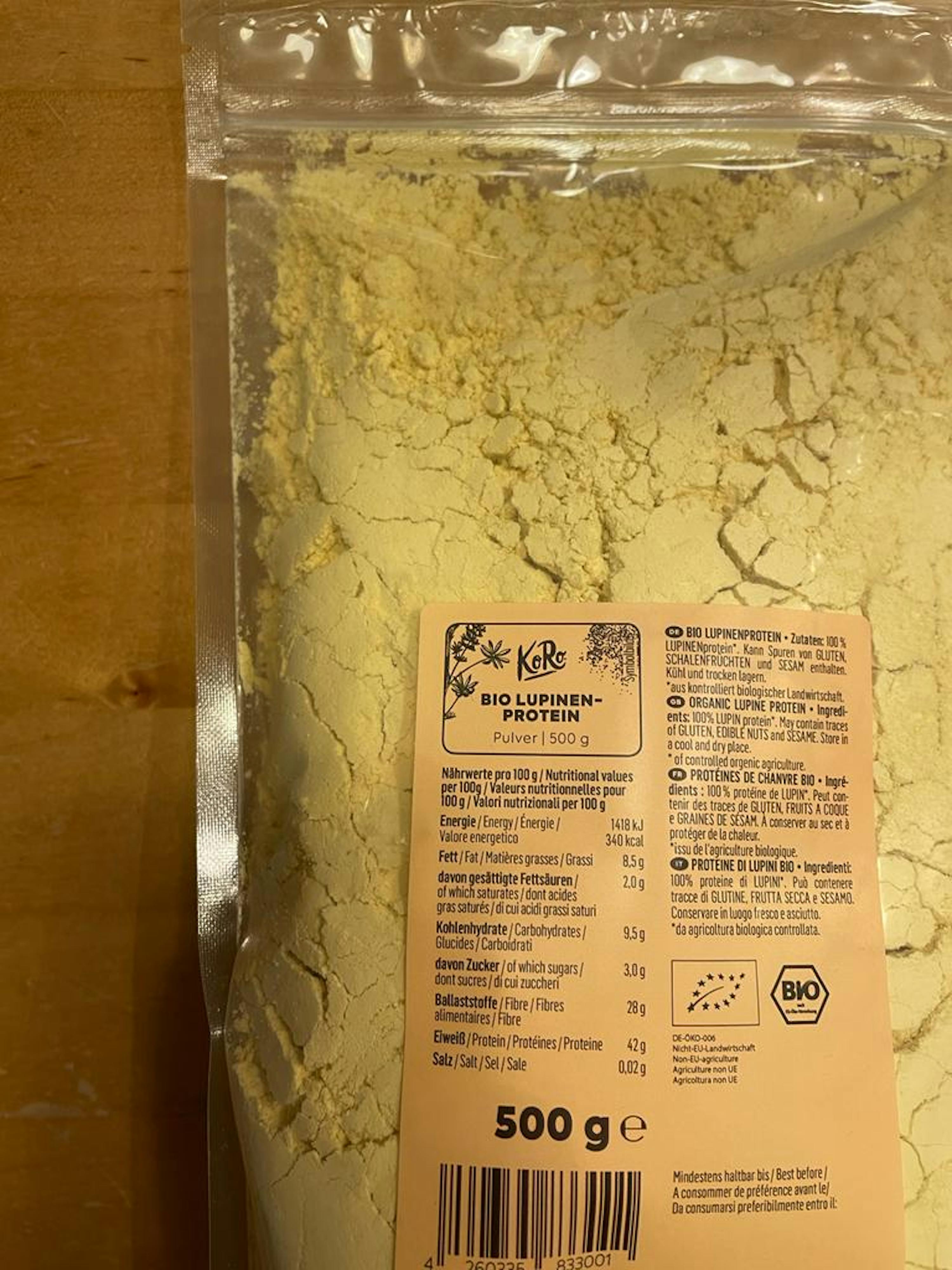un sac de poudre de lupin bio avec une étiquette orange sur une table en bois