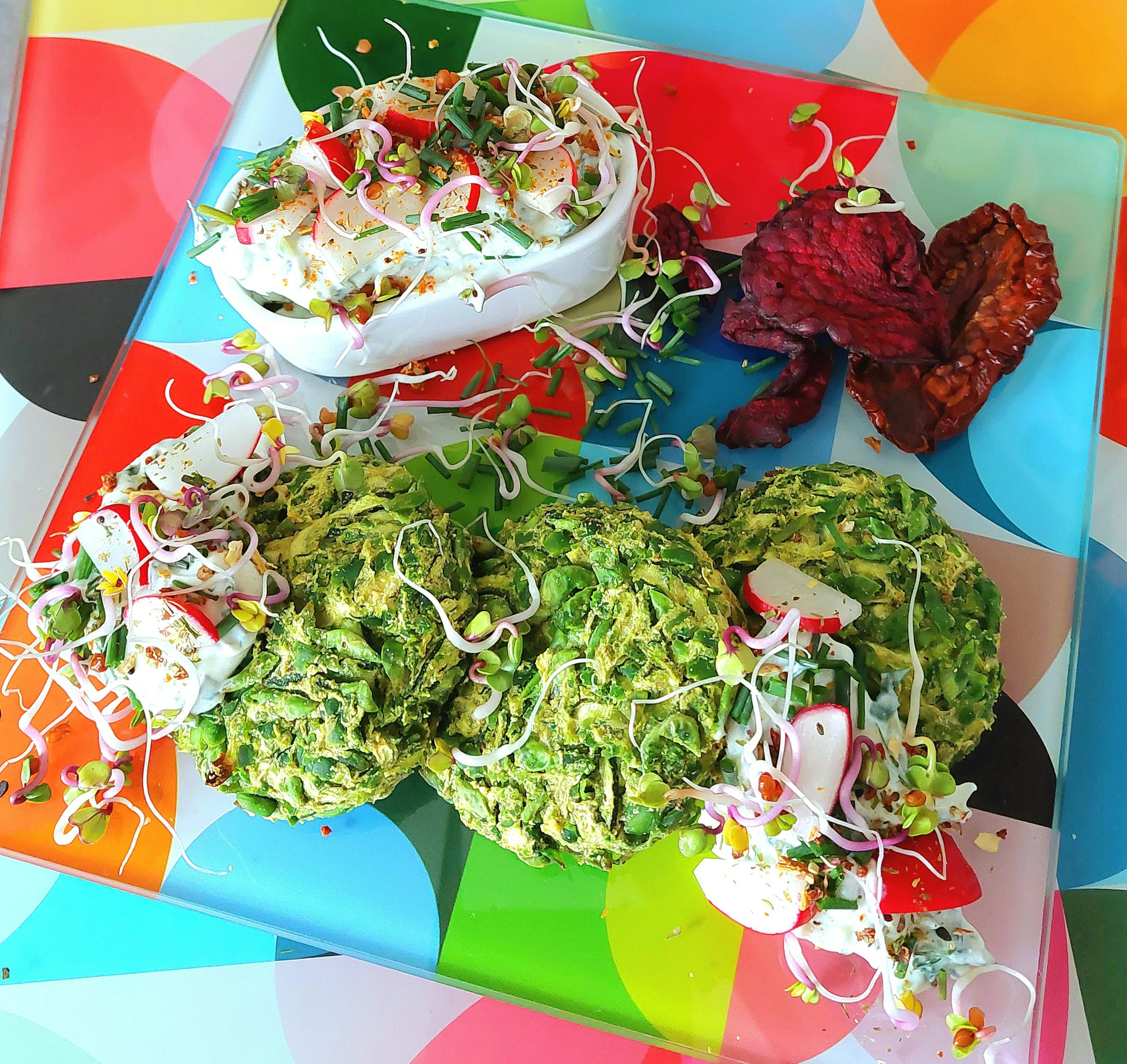 a plate of food on a colorful table cloth with a heart shaped item in the background