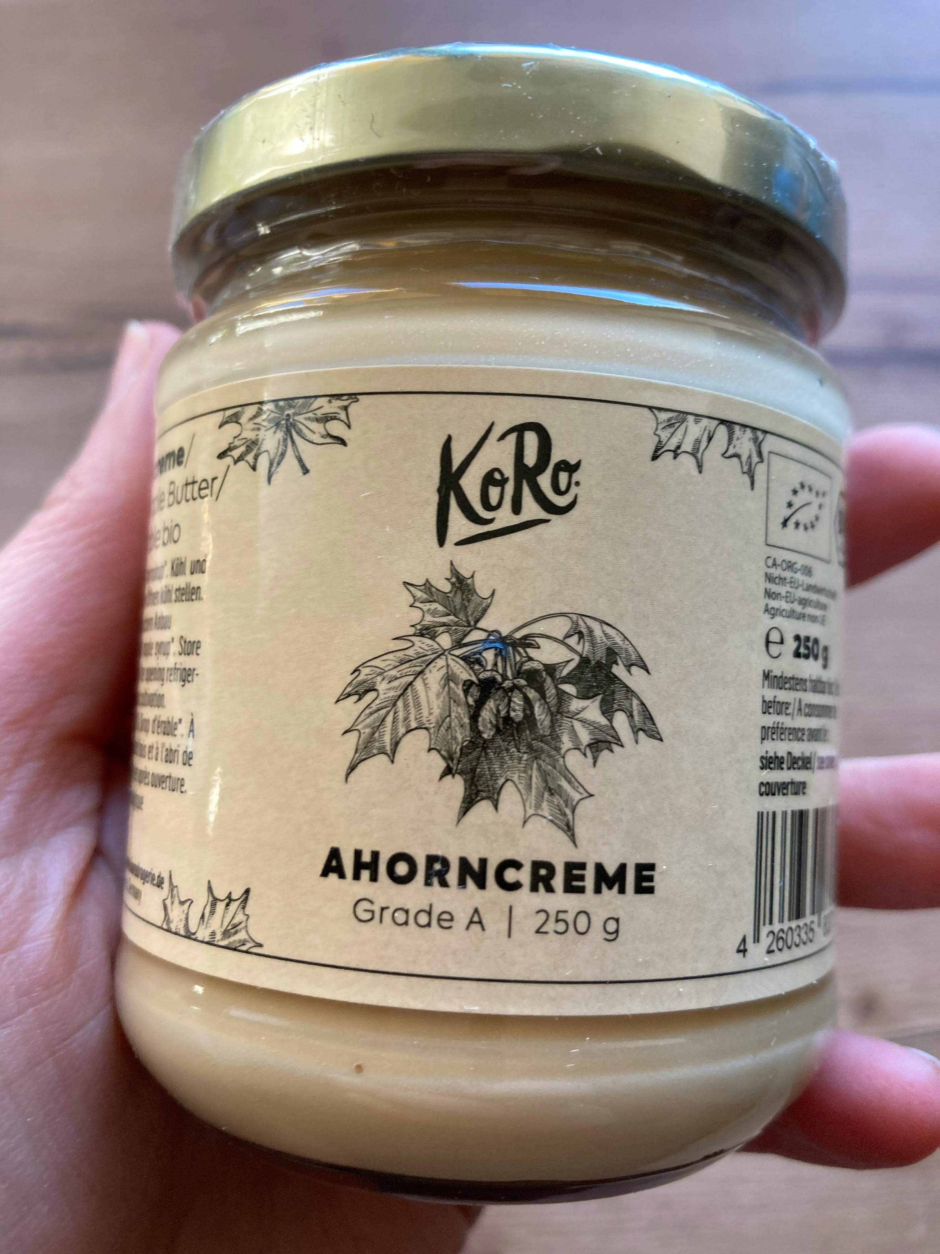 a person is holding a jar of ahorncreme