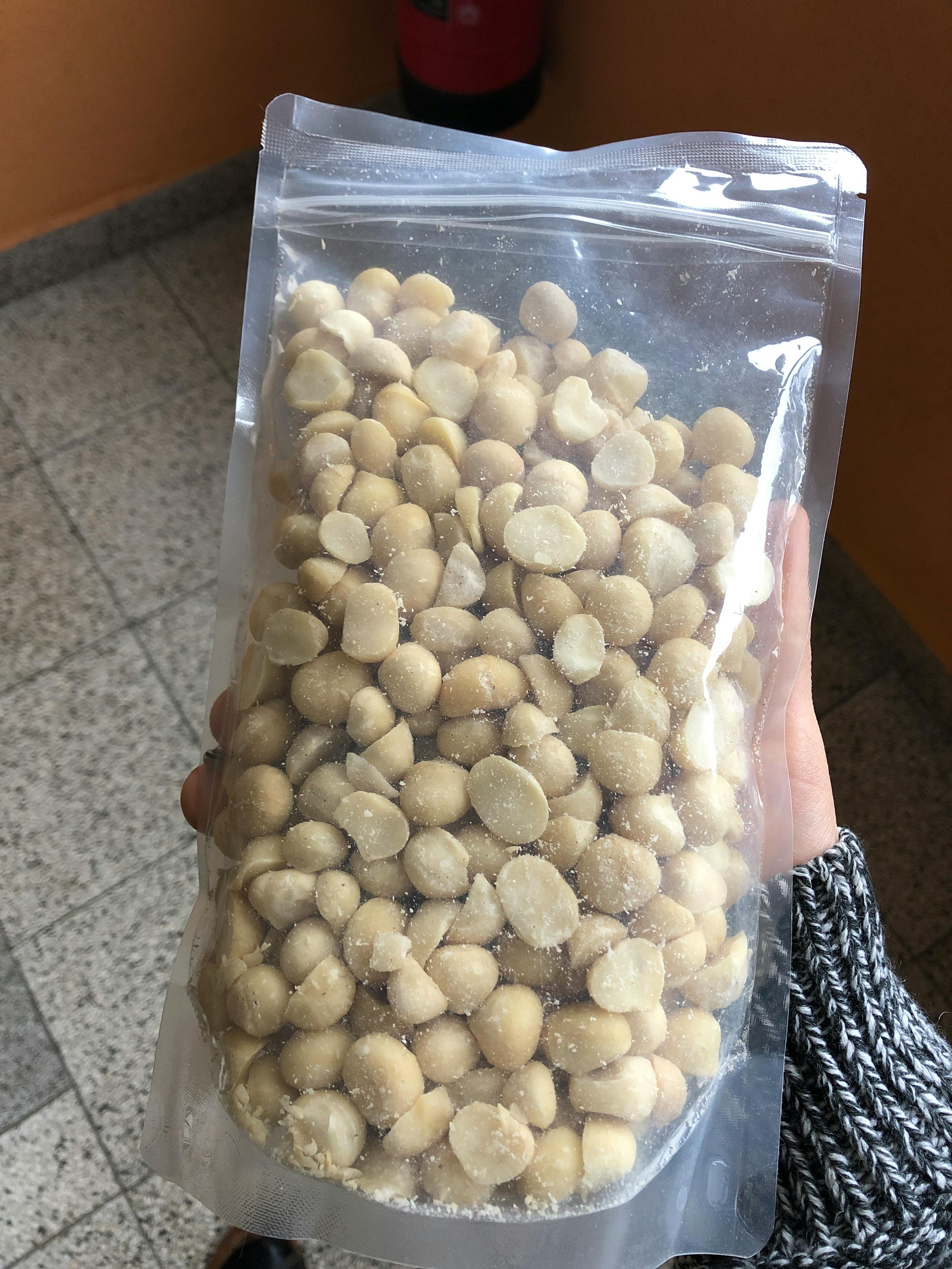 una persona tiene in mano un sacchetto di arachidi tostate