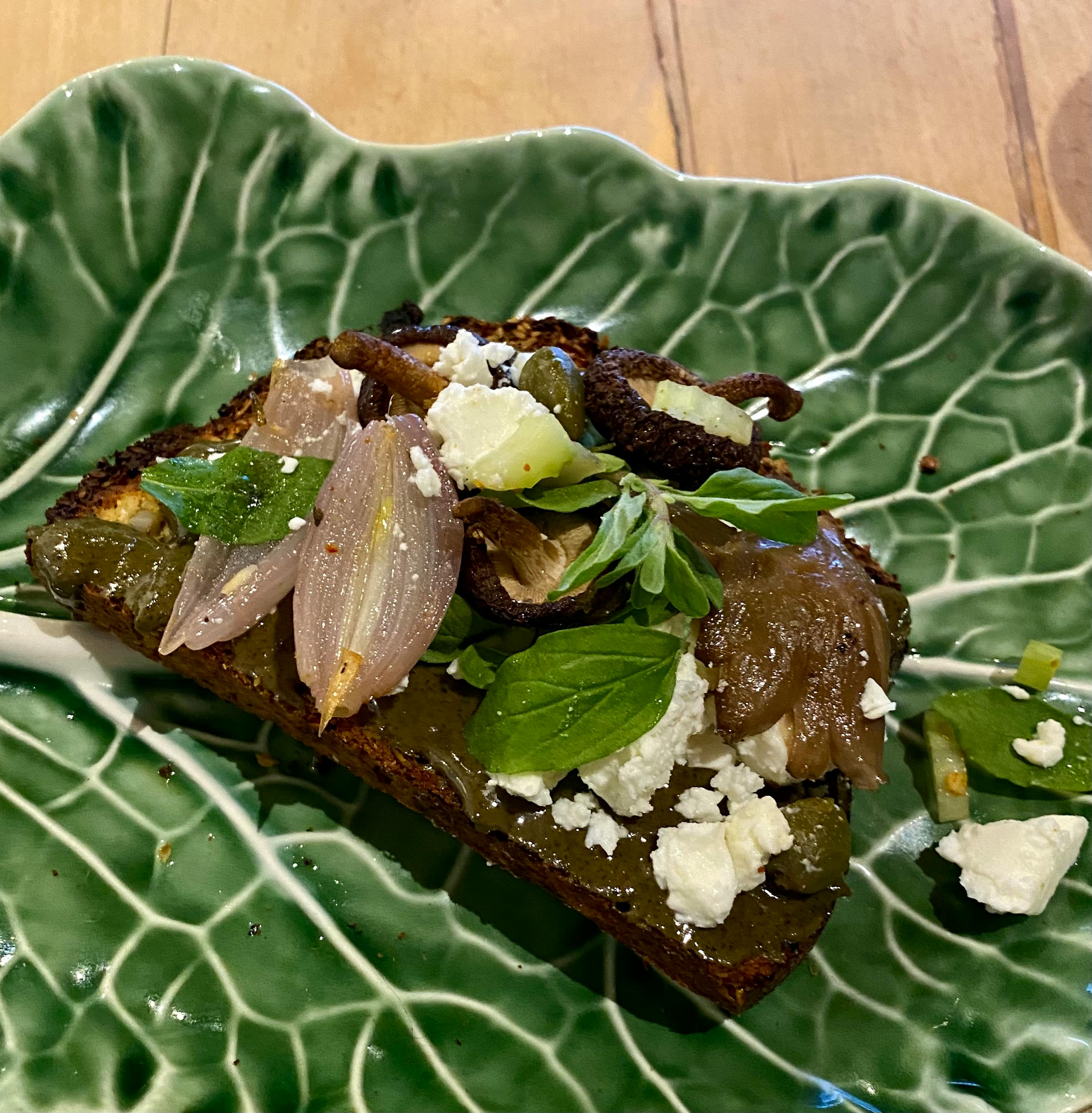 a green leaf shaped plate with a piece of food on it