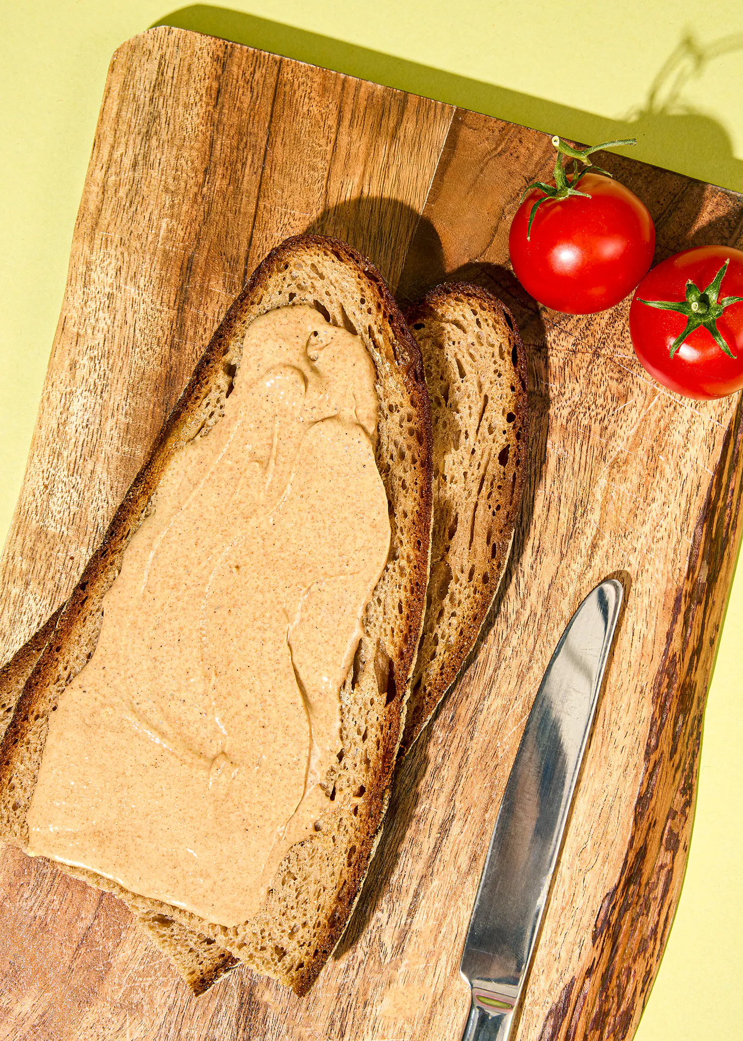 ein Stück Brot mit Erdnussbutter auf einem Schneidebrett