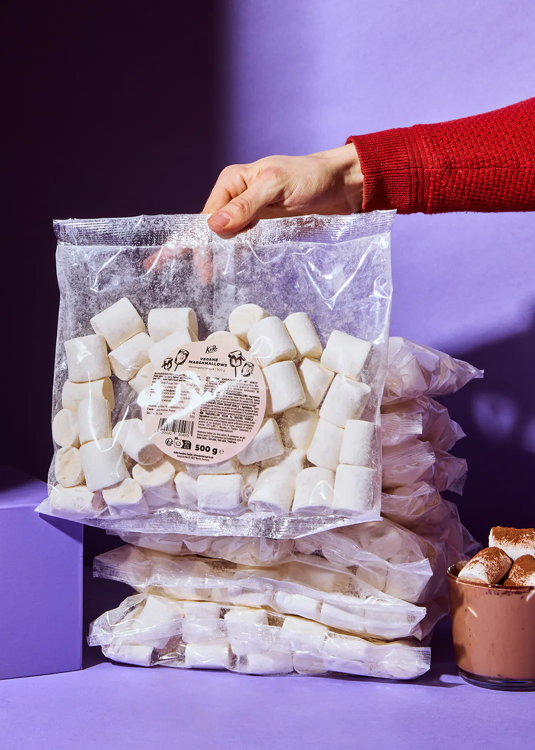 Eine Person hält eine Tüte Marshmallows in der Hand