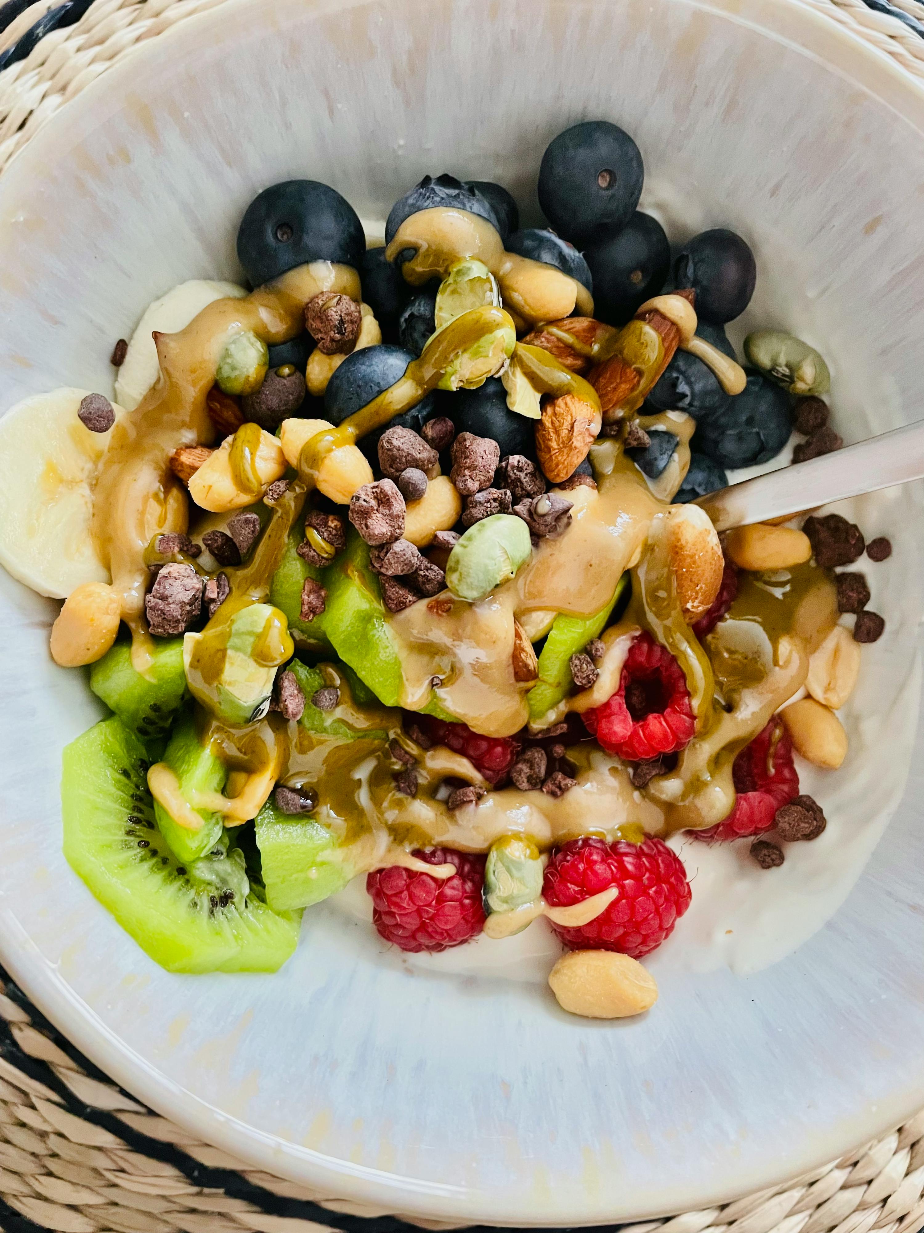 a bowl filled with fruit and nuts with a spoon in it