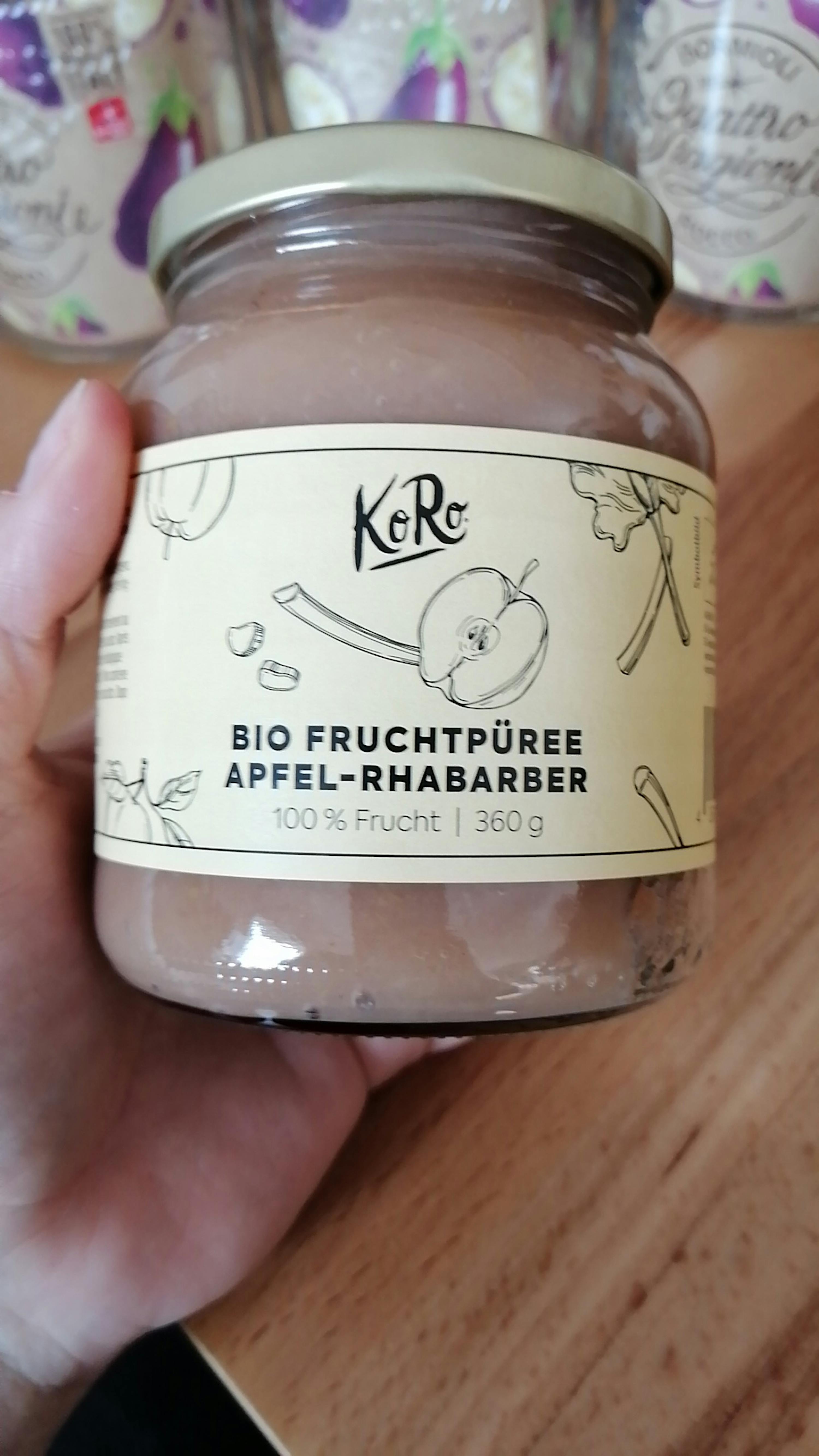 una persona tiene in mano un barattolo di purea di frutta bio