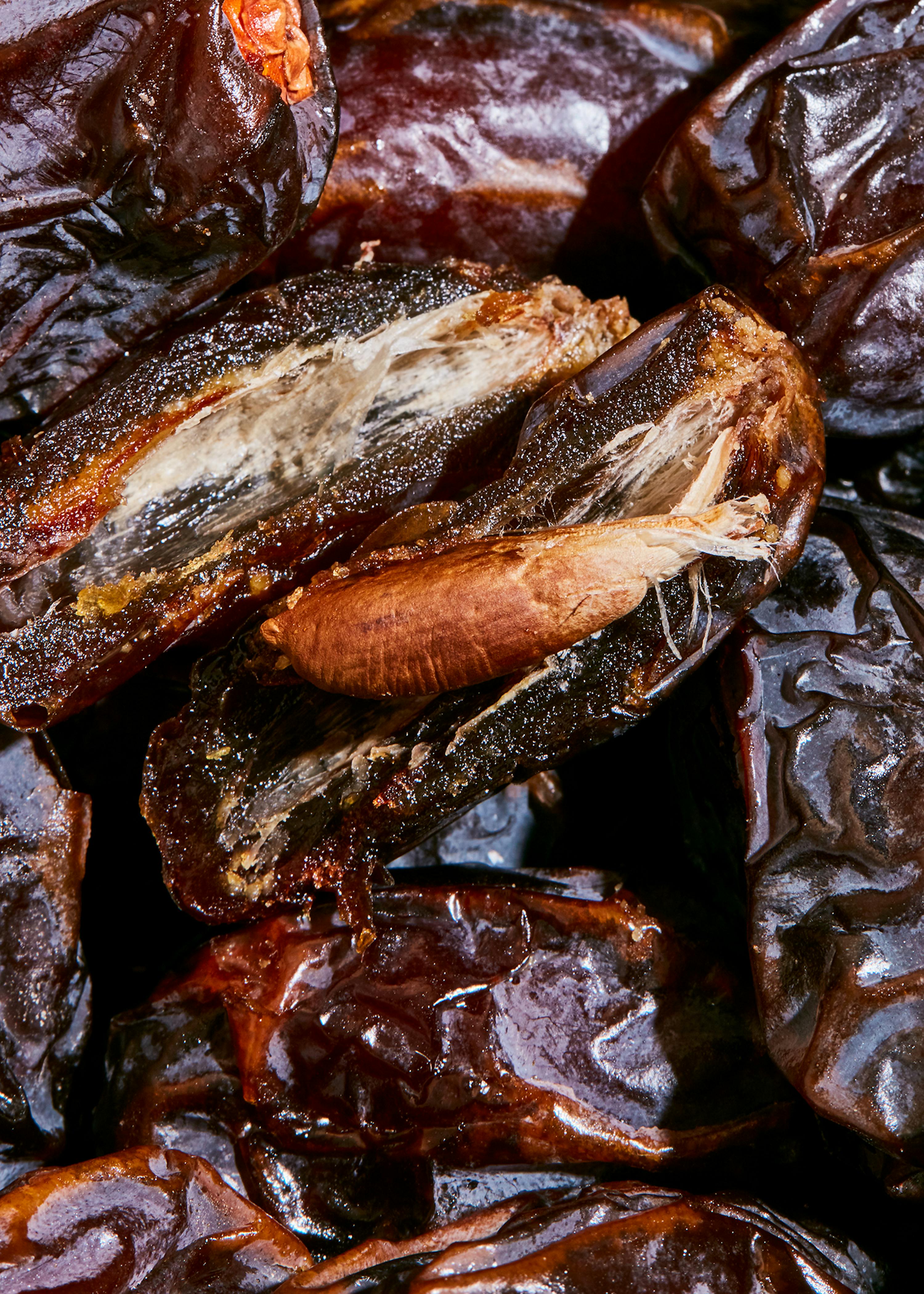 a close up of a pile of dates with one being cut in half