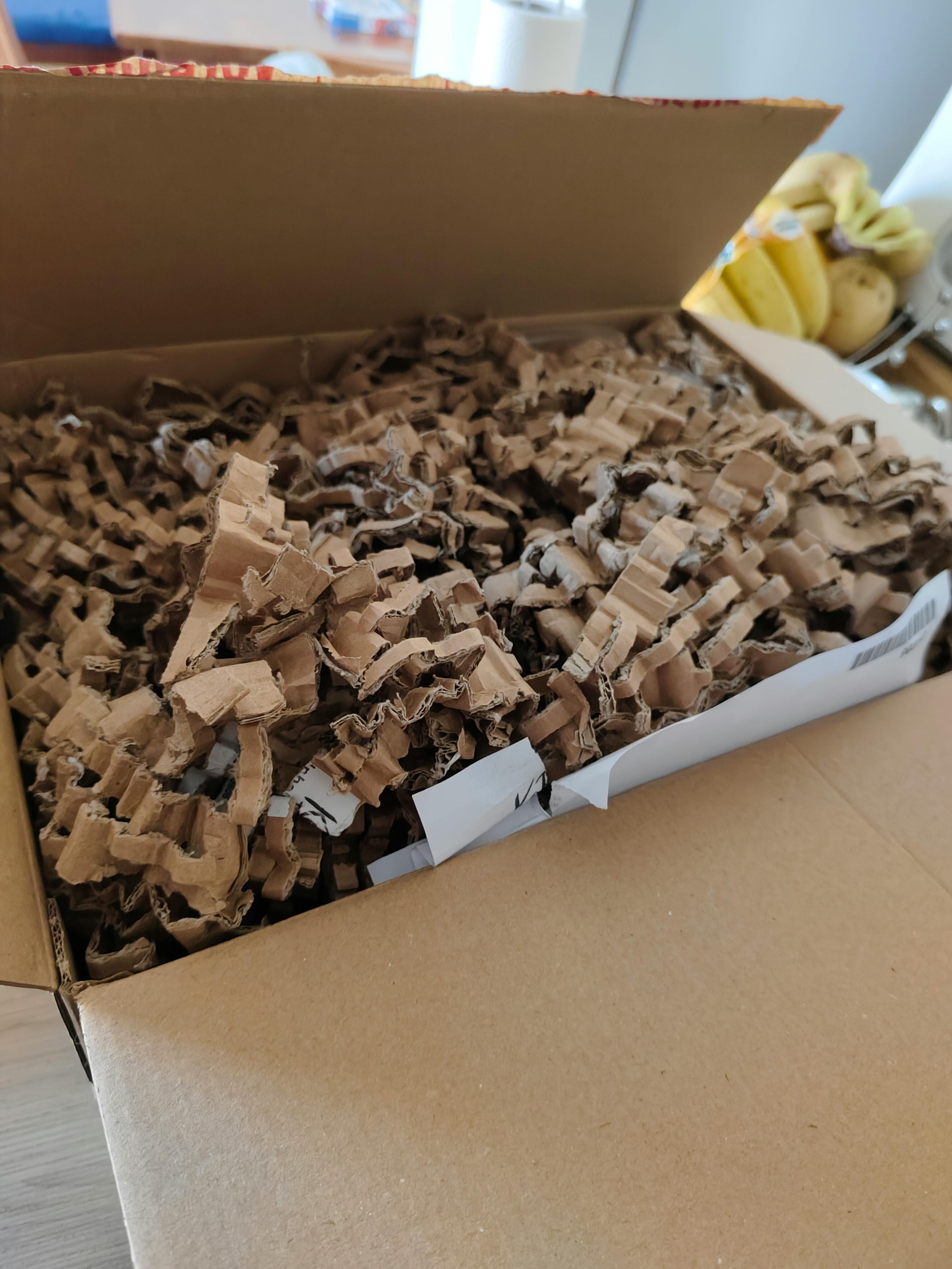 eine Schachtel voller brauner und weißer Pappe auf einem Tisch