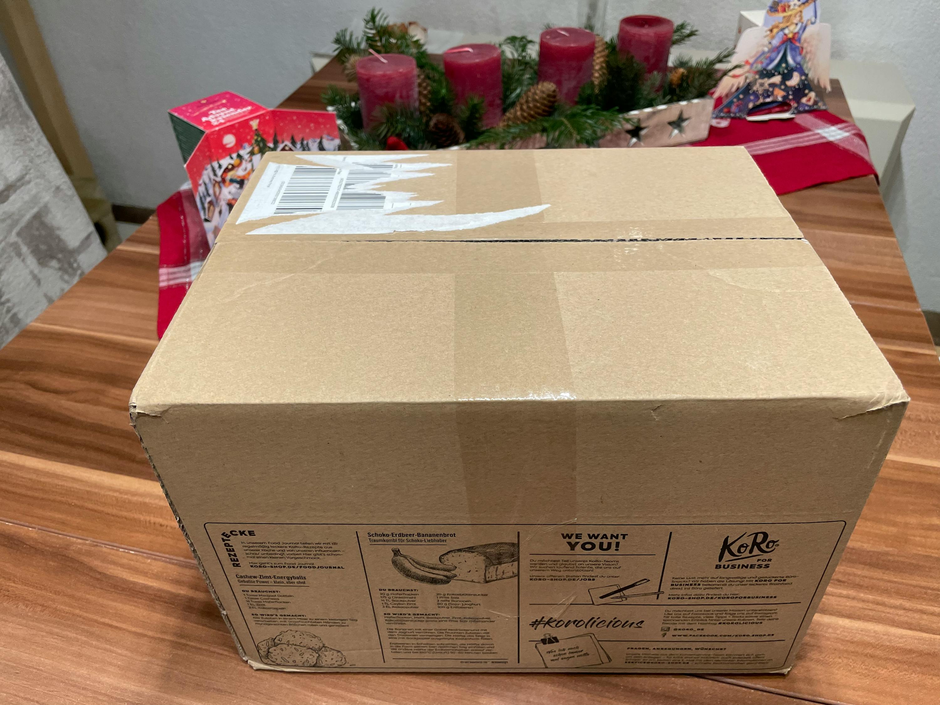 una scatola di cartone marrone è seduta su un tavolo di legno