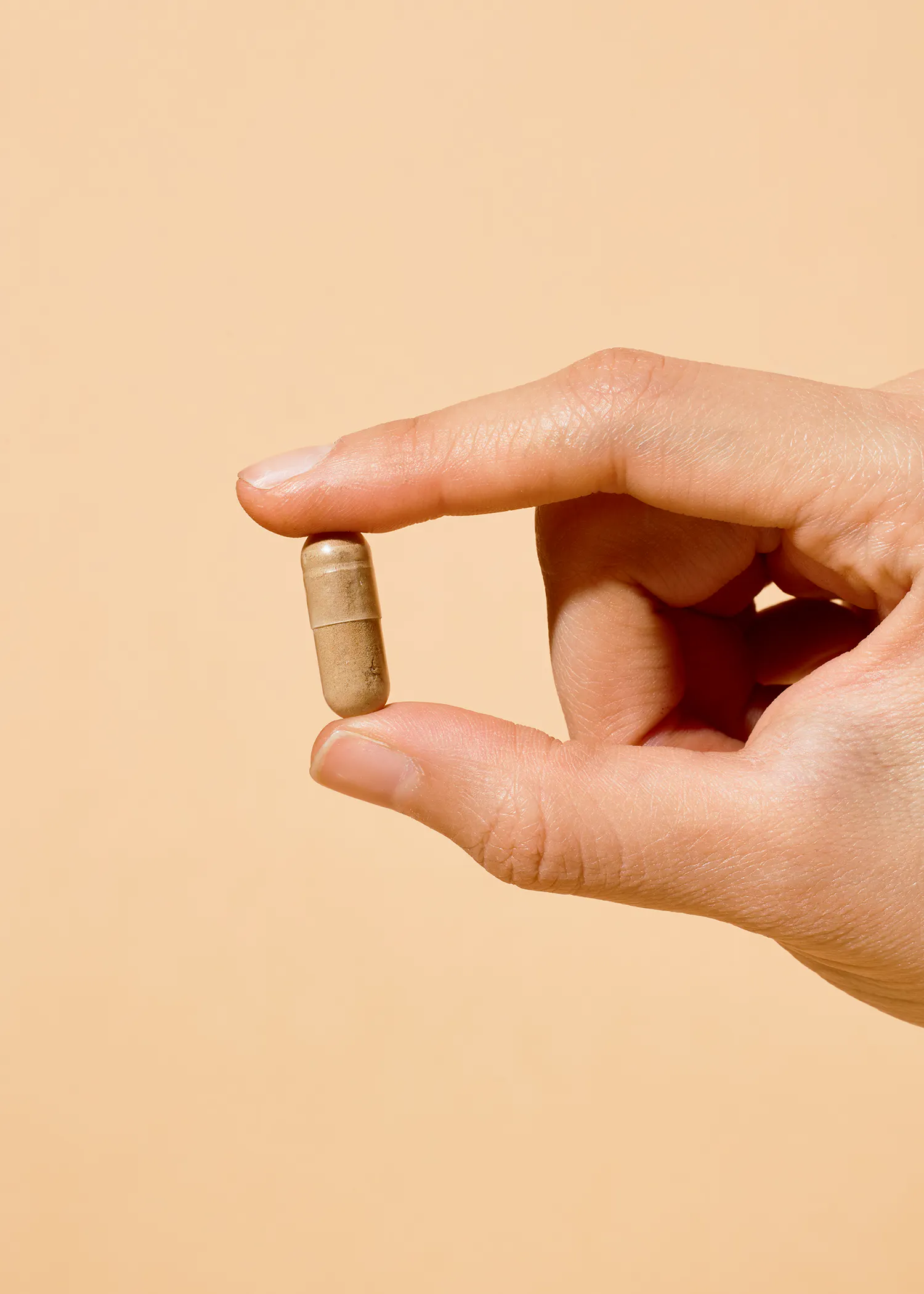 a person is holding a capsule with the letter a on it