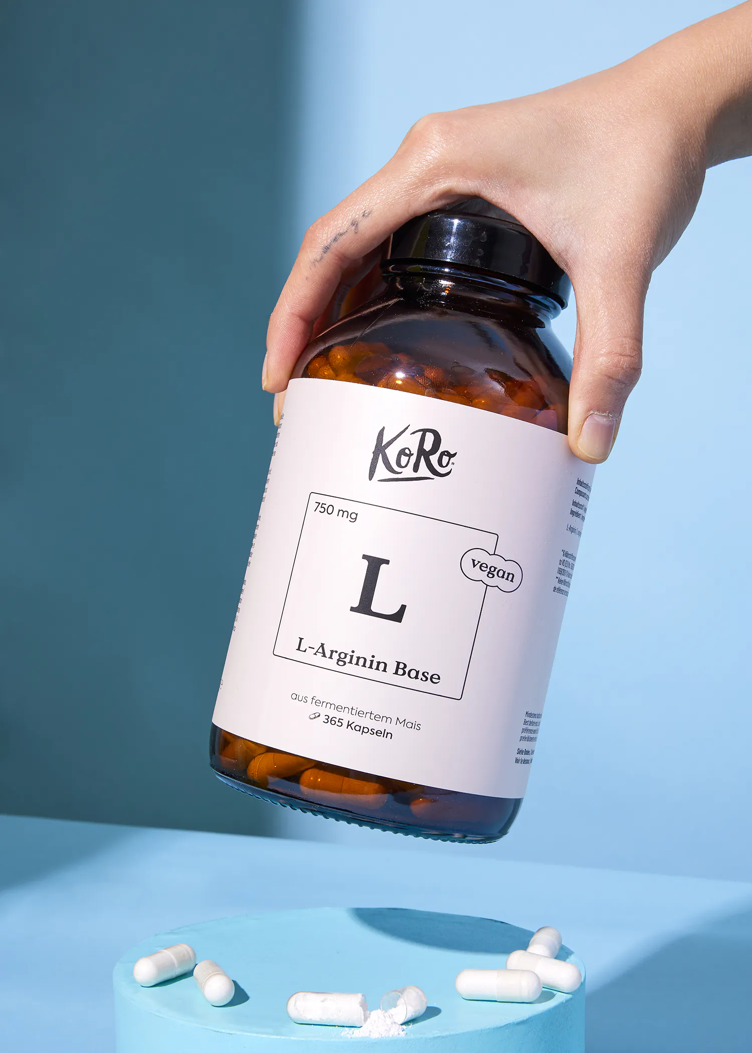 une personne tient une bouteille de l-arginine base