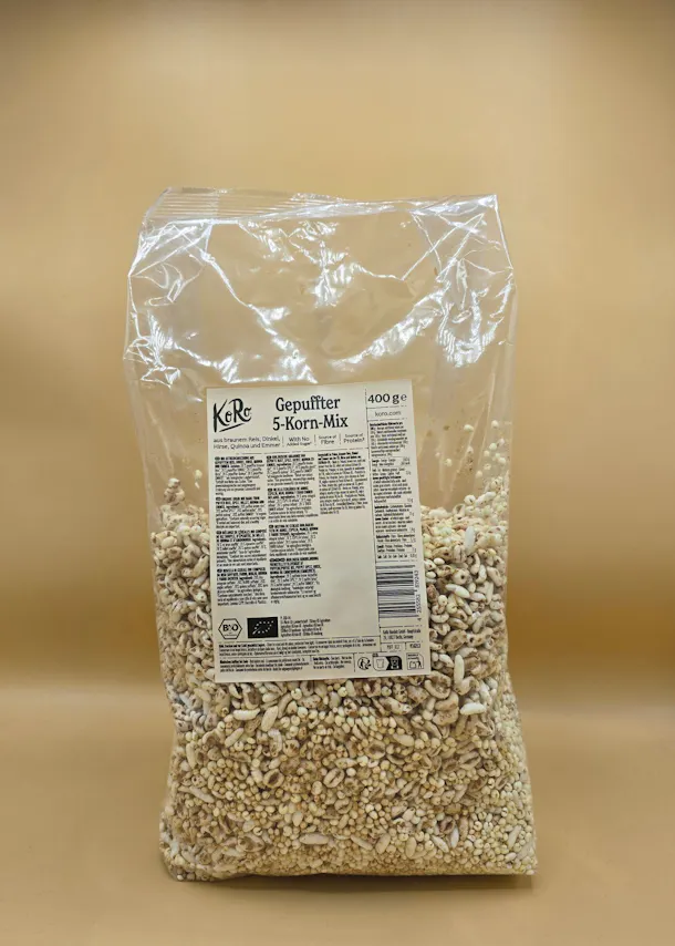 eine durchsichtige plastiktüte mit 400 gramm koro gepufftem 5-korn-mix aus braunem reis, dinkel, hirse, quinoa und emmer, mit bio-zertifizierung.