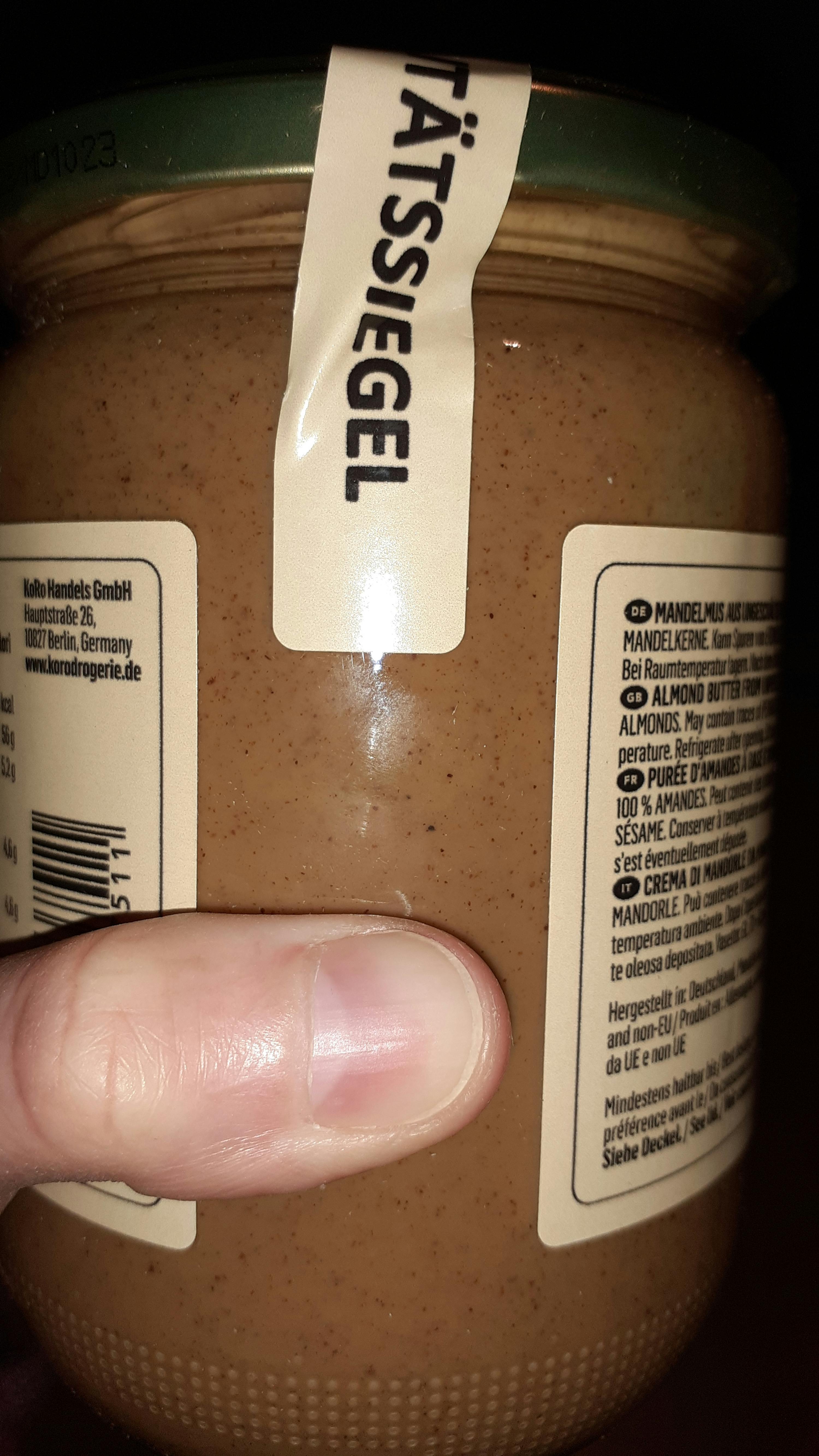 eine Person zeigt auf die Rückseite eines Glases Erdnussbutter