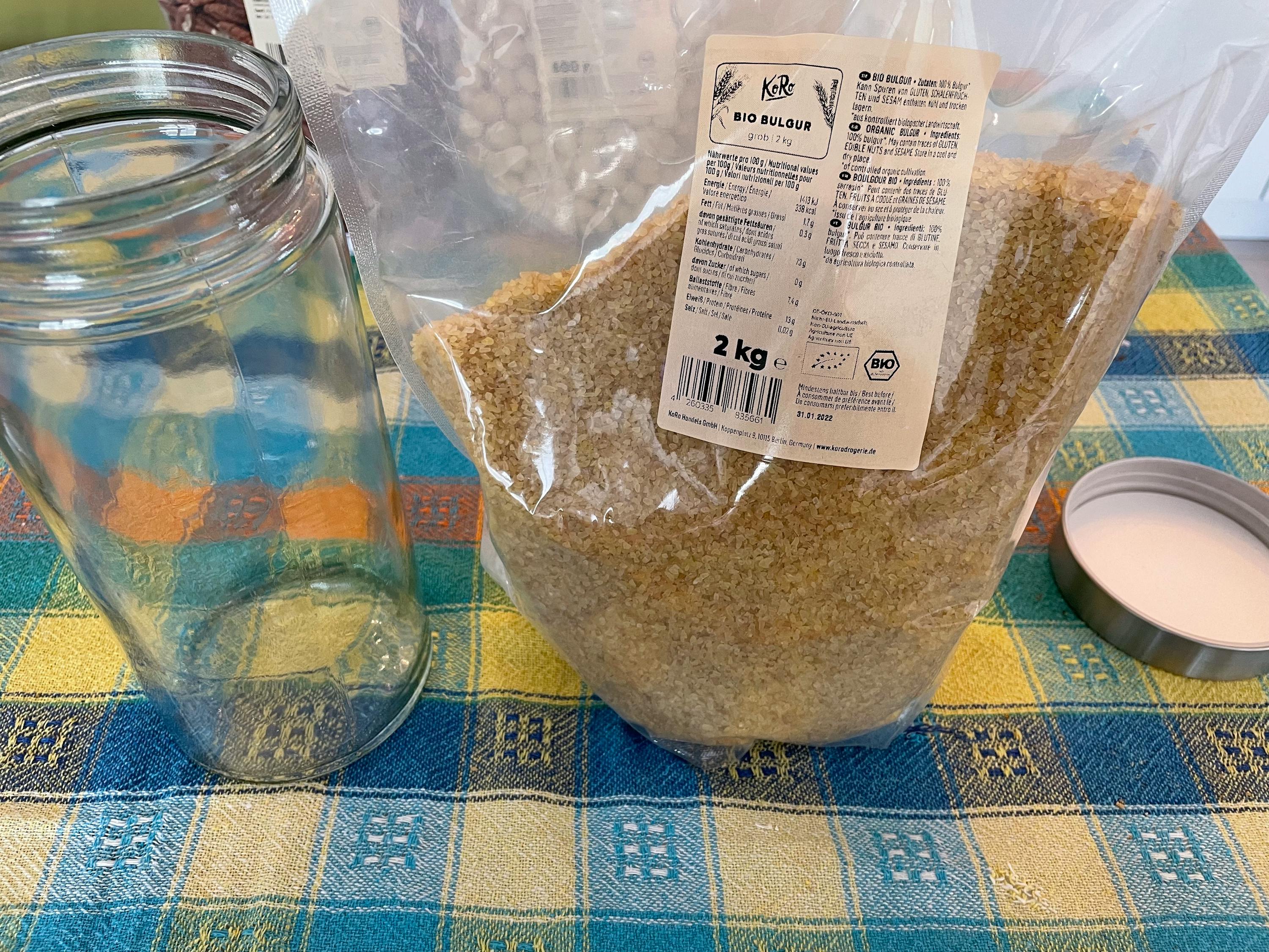 ein Glas mit einem Etikett auf der Rückseite steht neben einem Plastikbeutel mit einem Gewicht von 2 kg