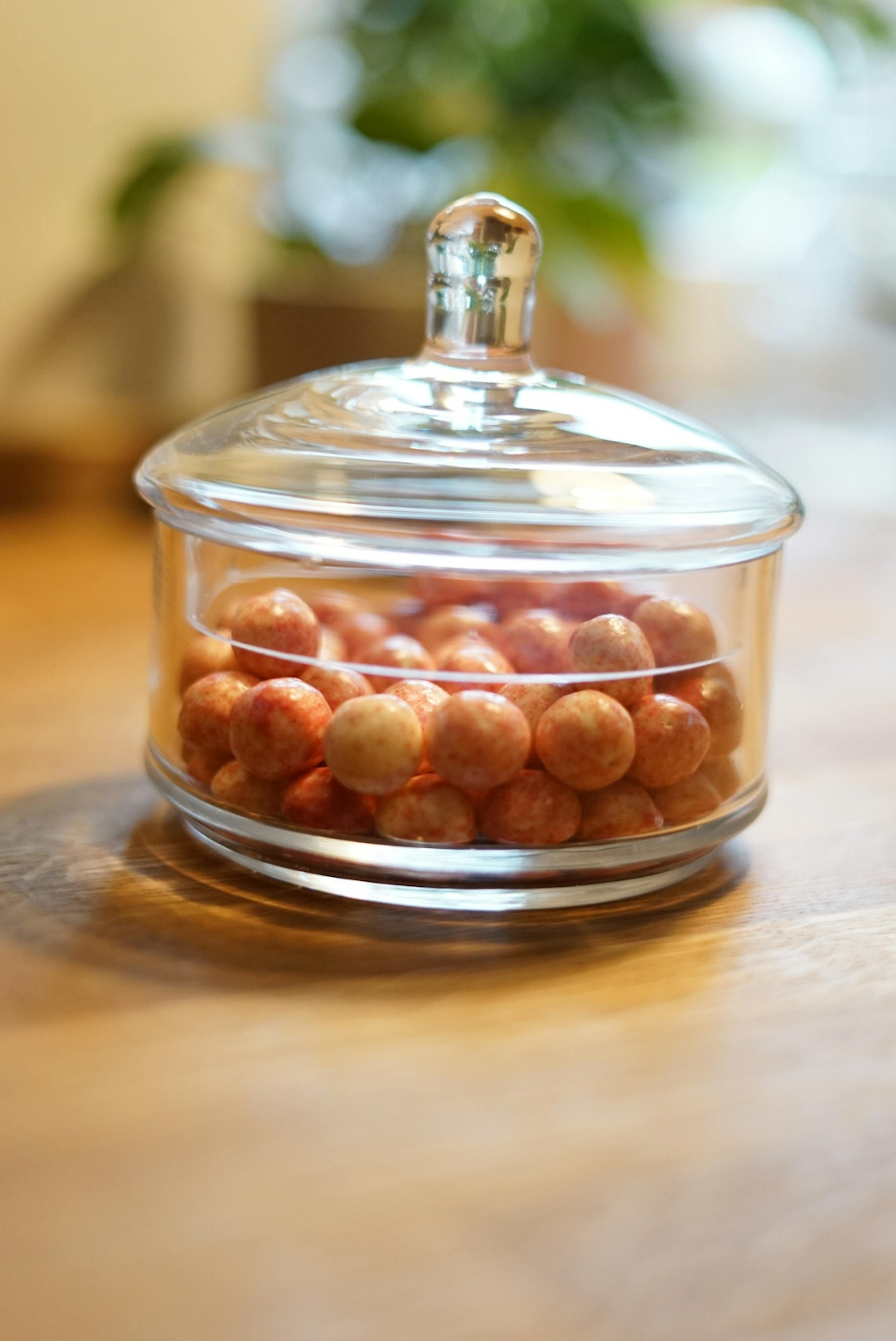 a glass jar filled with nuts sits on a wooden table