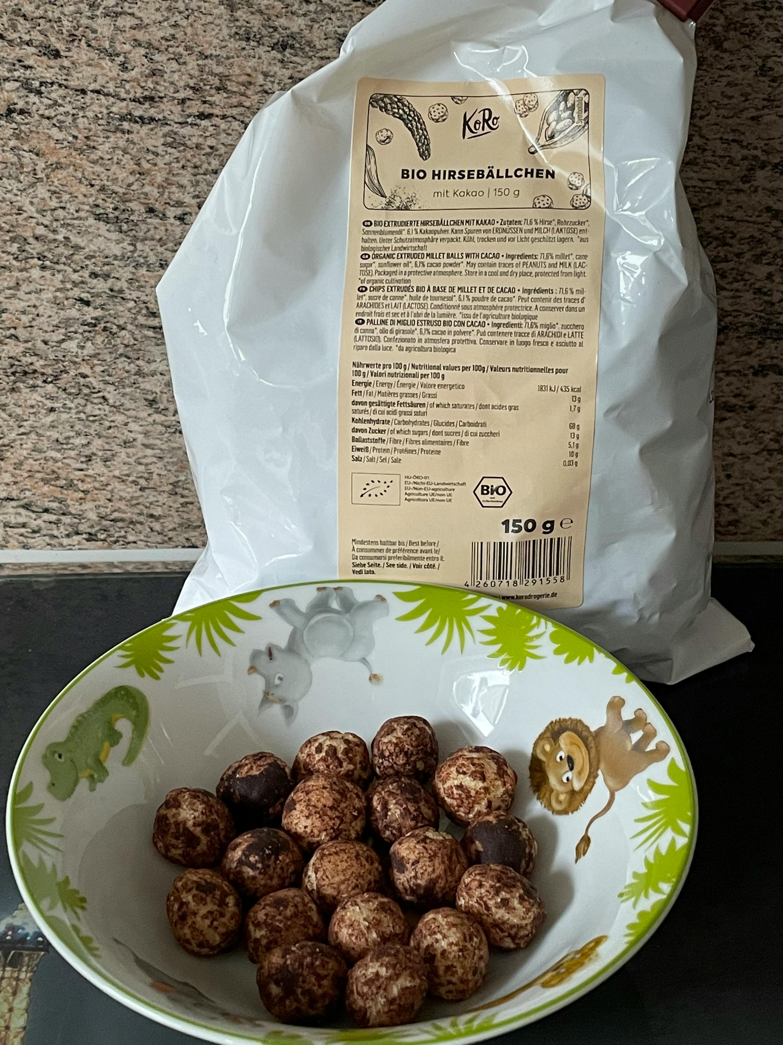 eine Tüte bio-Hirseballchen liegt neben einem Teller mit Hirseballchen