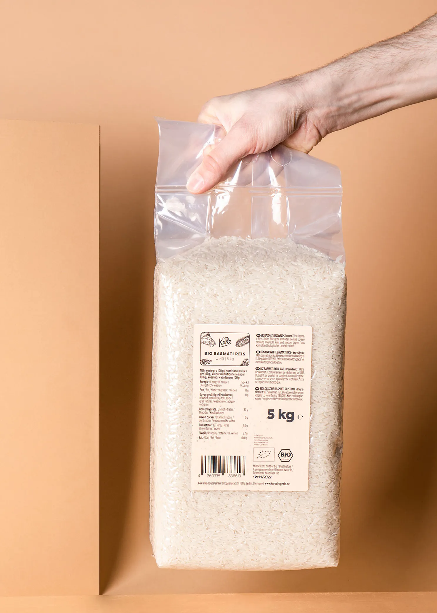 eine Person hält einen Plastikbeutel mit Reis in der Hand