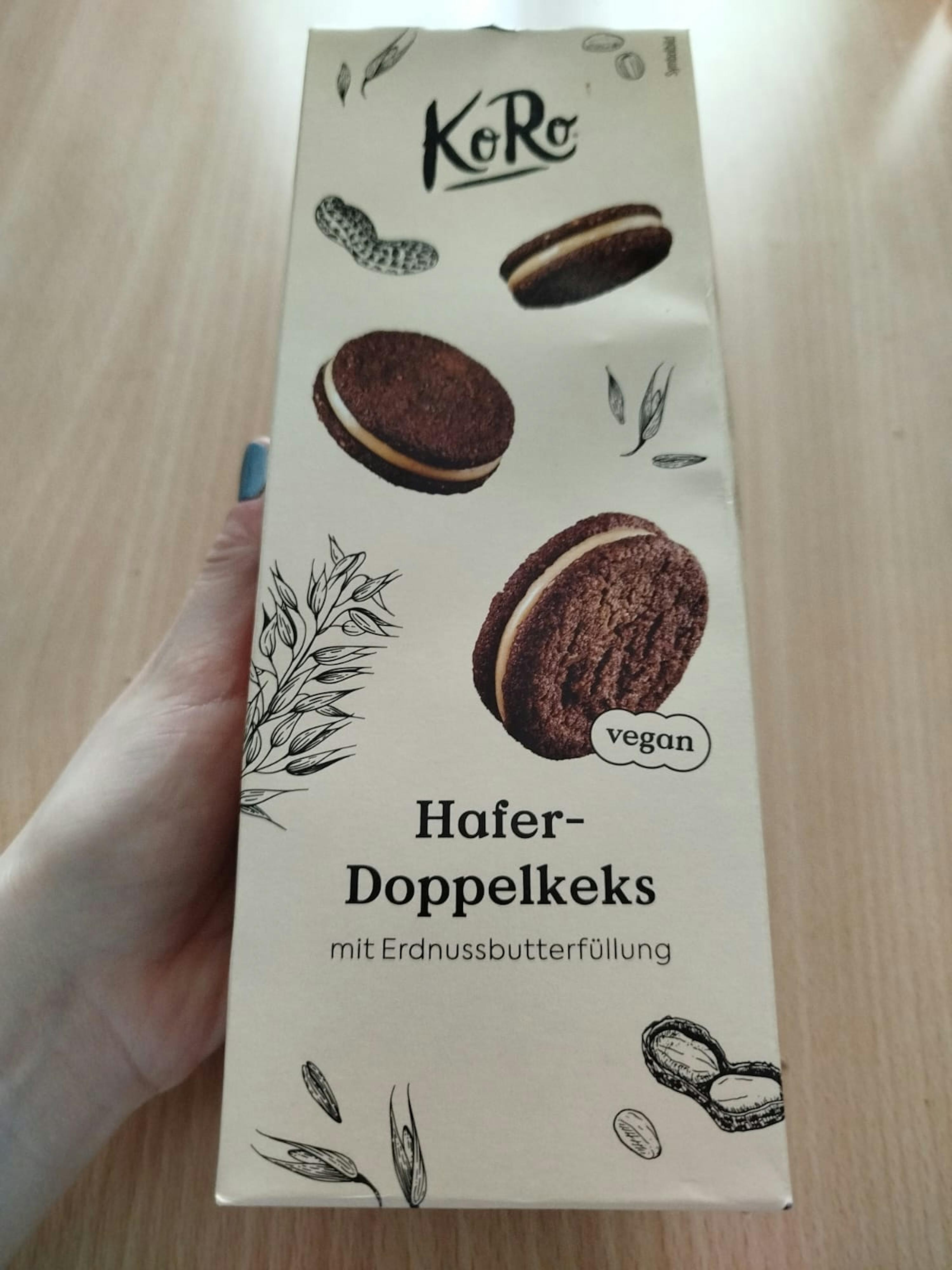 Eine Person hält eine Schachtel hafer-doppelkeks mit Erdnussbutterfüllung