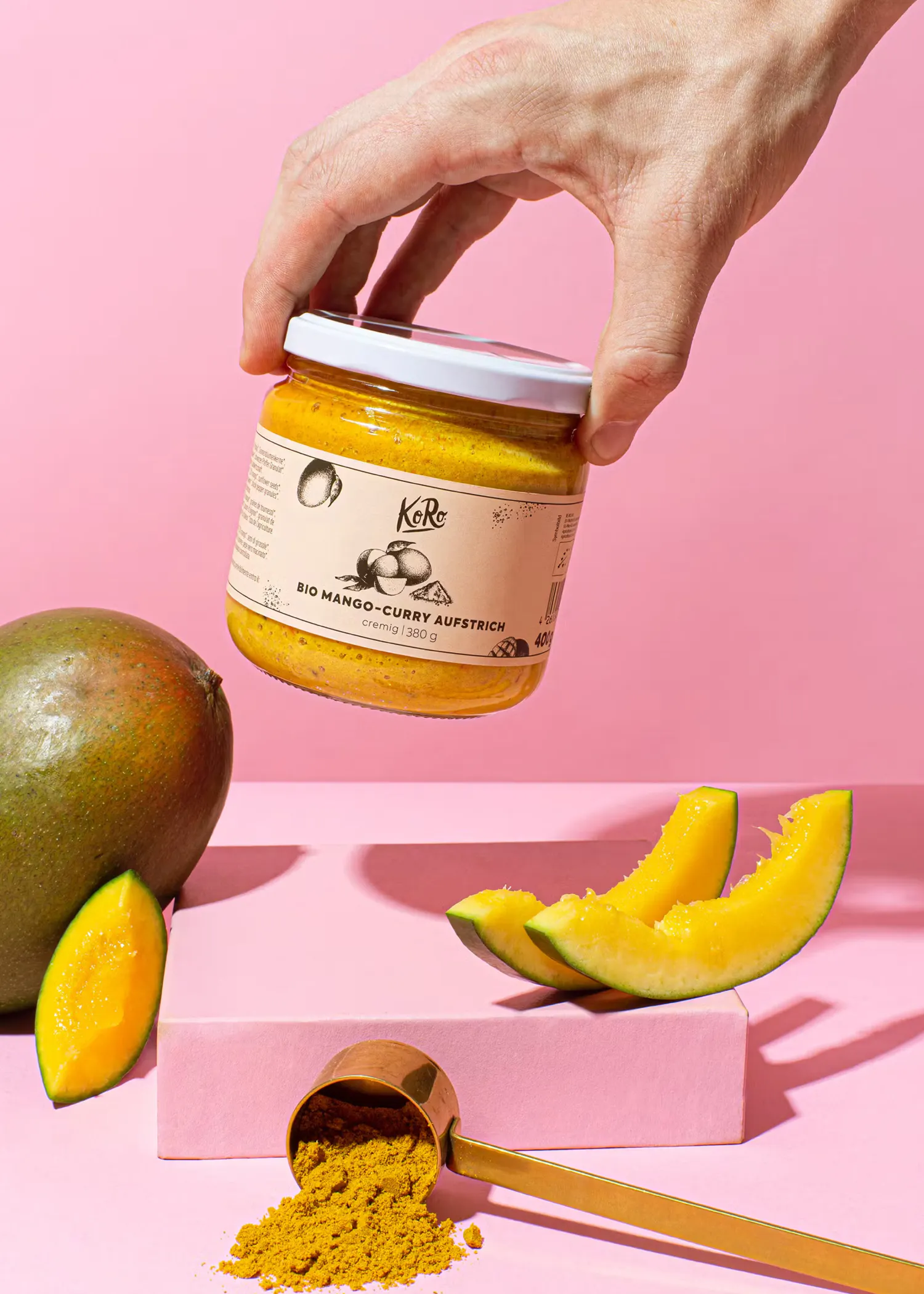 a person is holding a jar of mango curry sauce