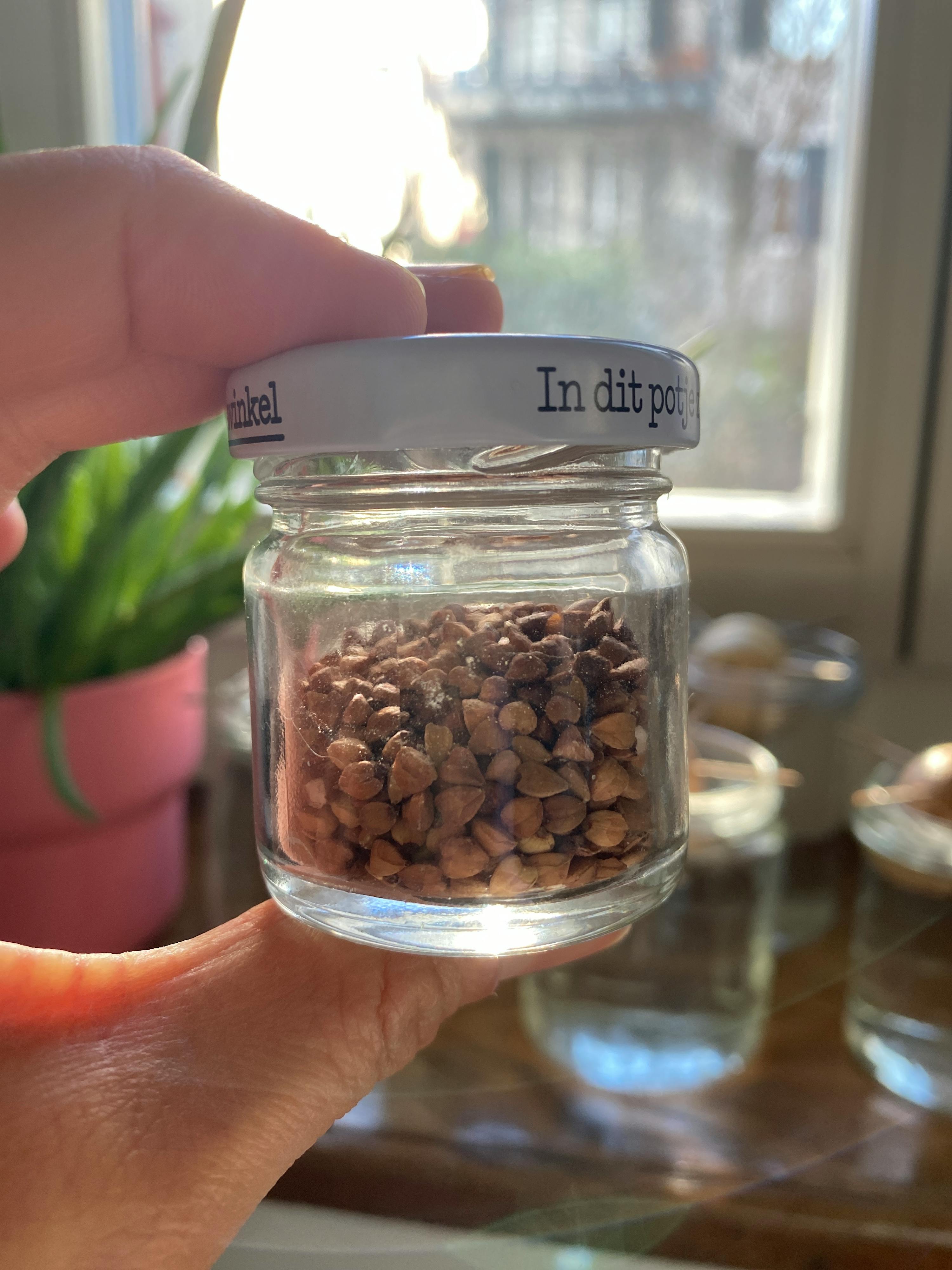 a person is holding a jar with a label that says in dit pot