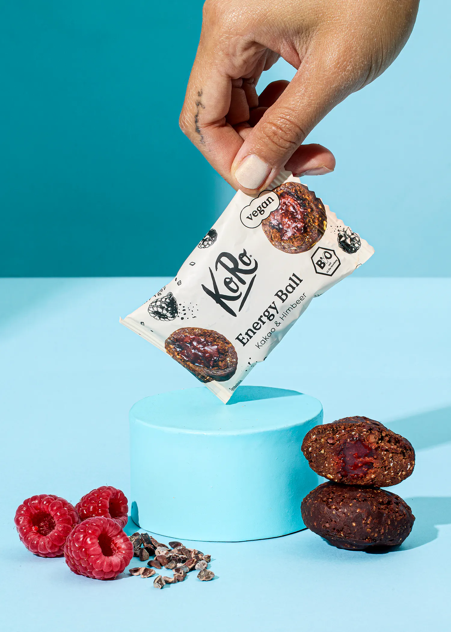 une personne tient une barre d' énergie à côté de framboises