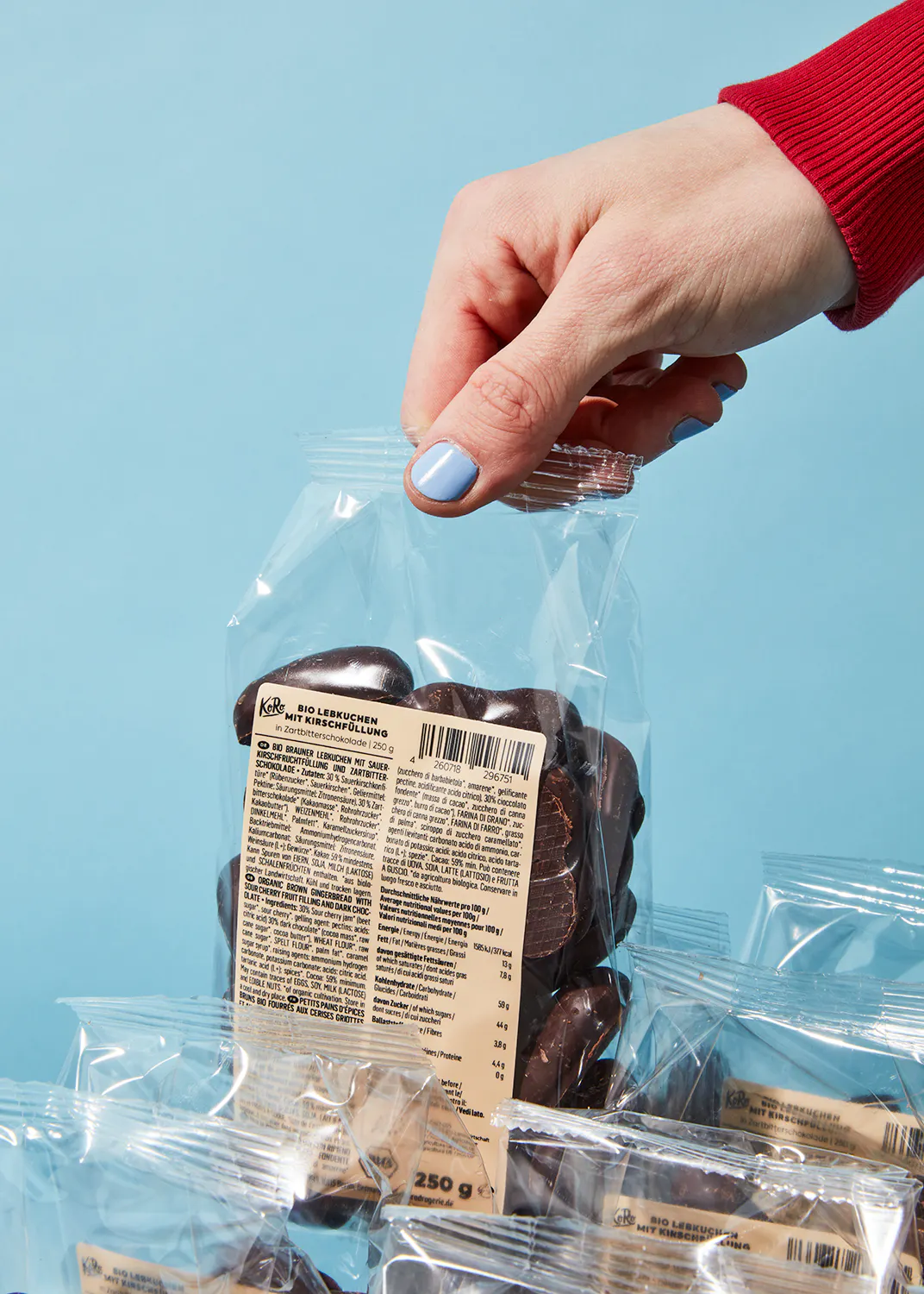 a person is holding a bag of chocolate covered cookies