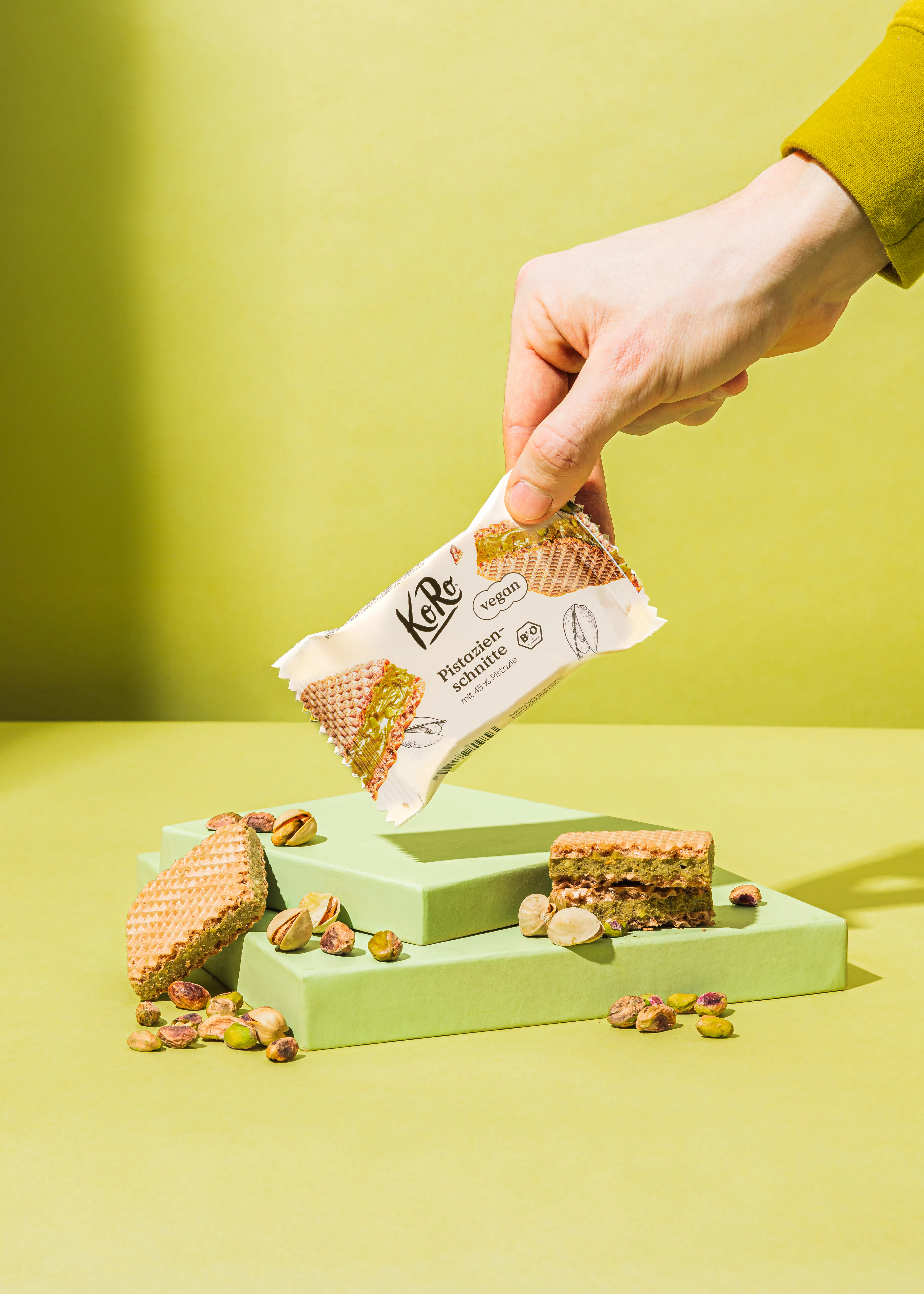 une personne tient une barre de gâteau à la pistache