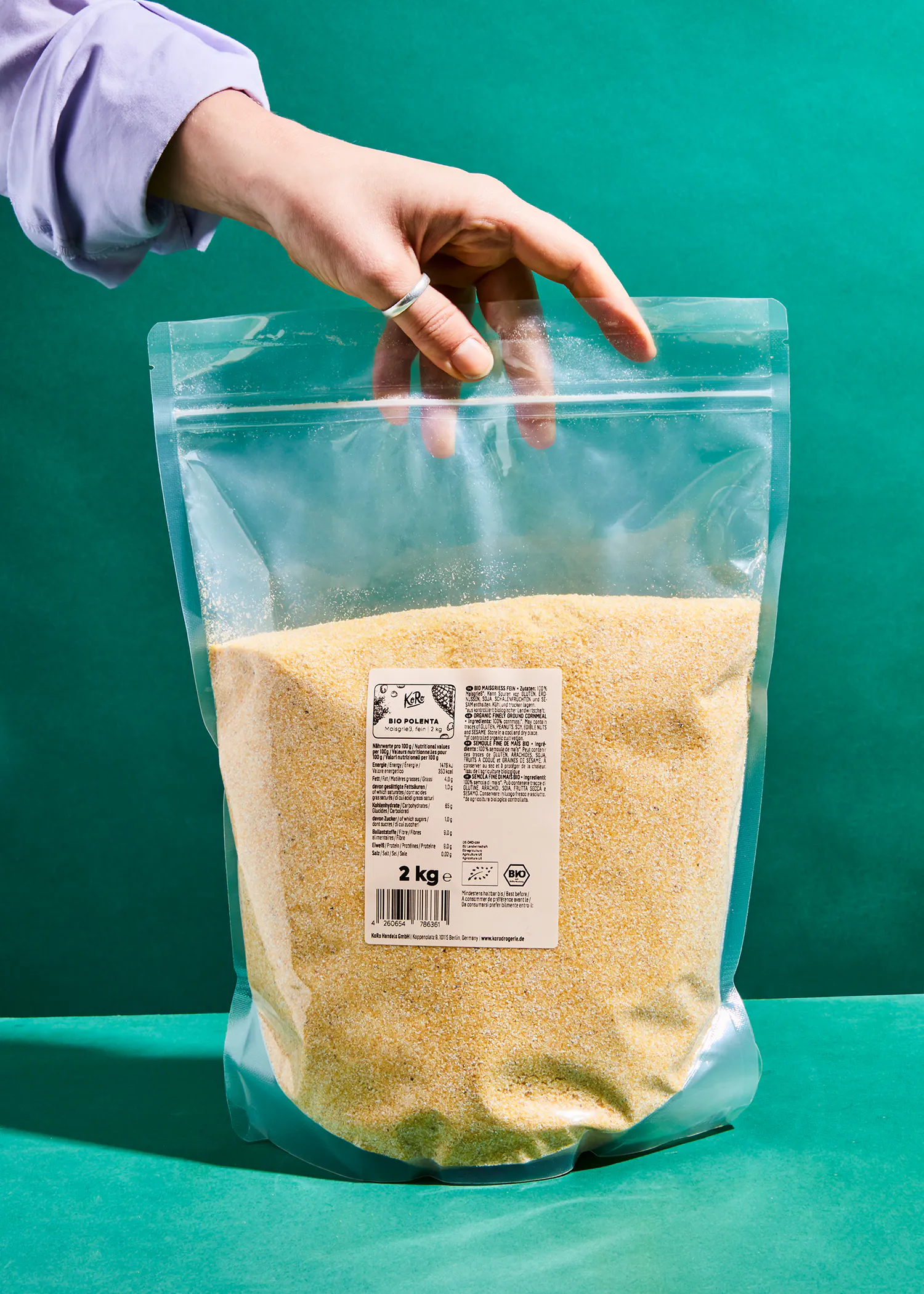 a person is holding a bag of food that says 2 kg