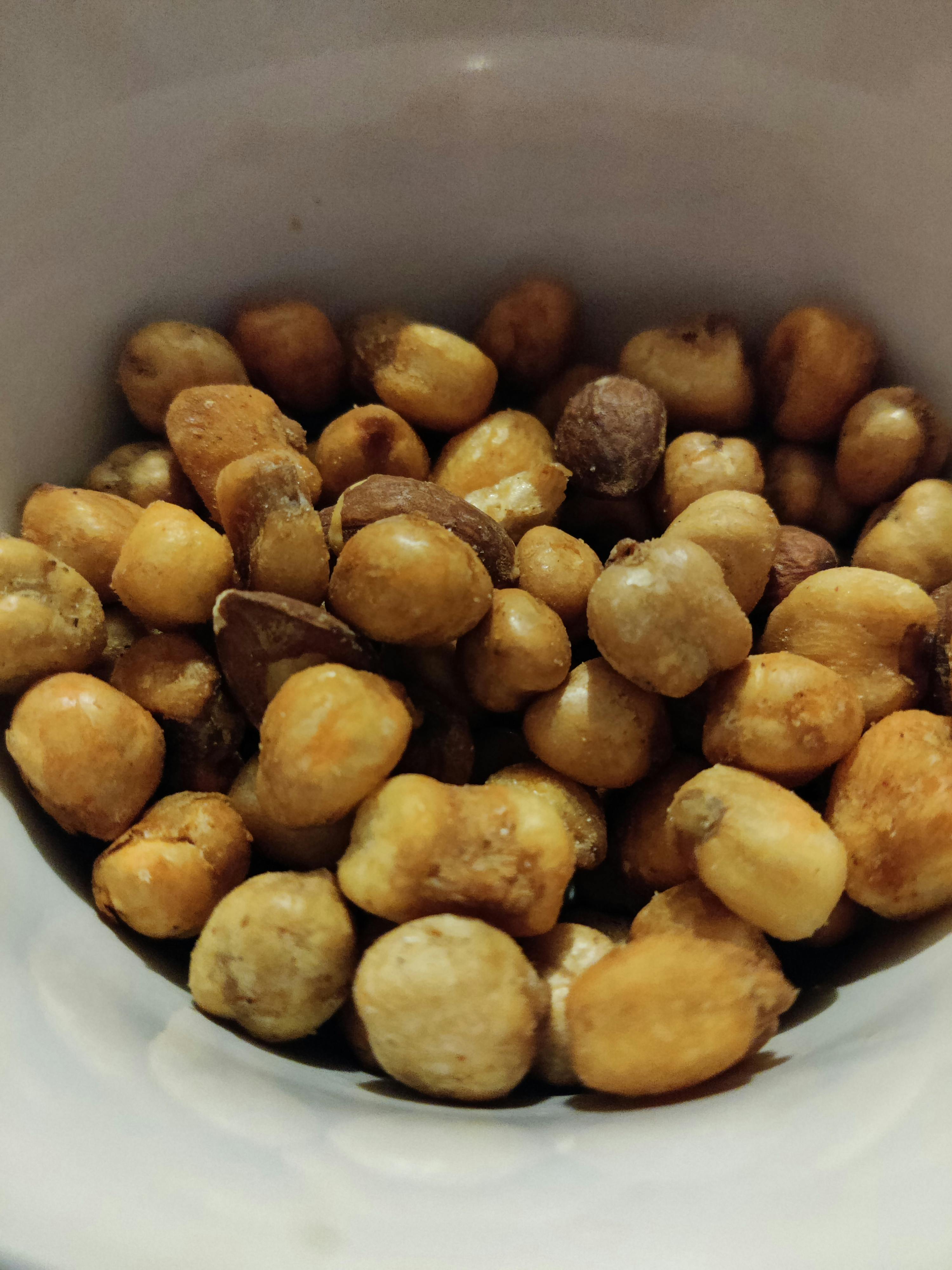 a white bowl filled with corn nuts and almonds