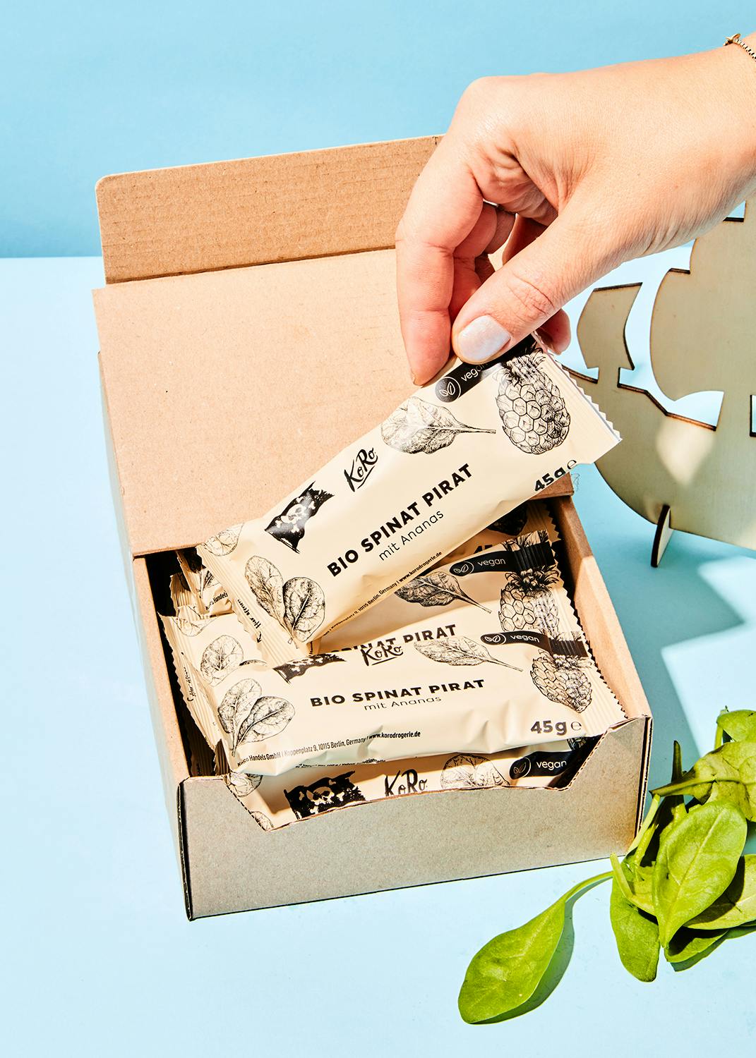 a person is opening a box of bio spinat pirat bars