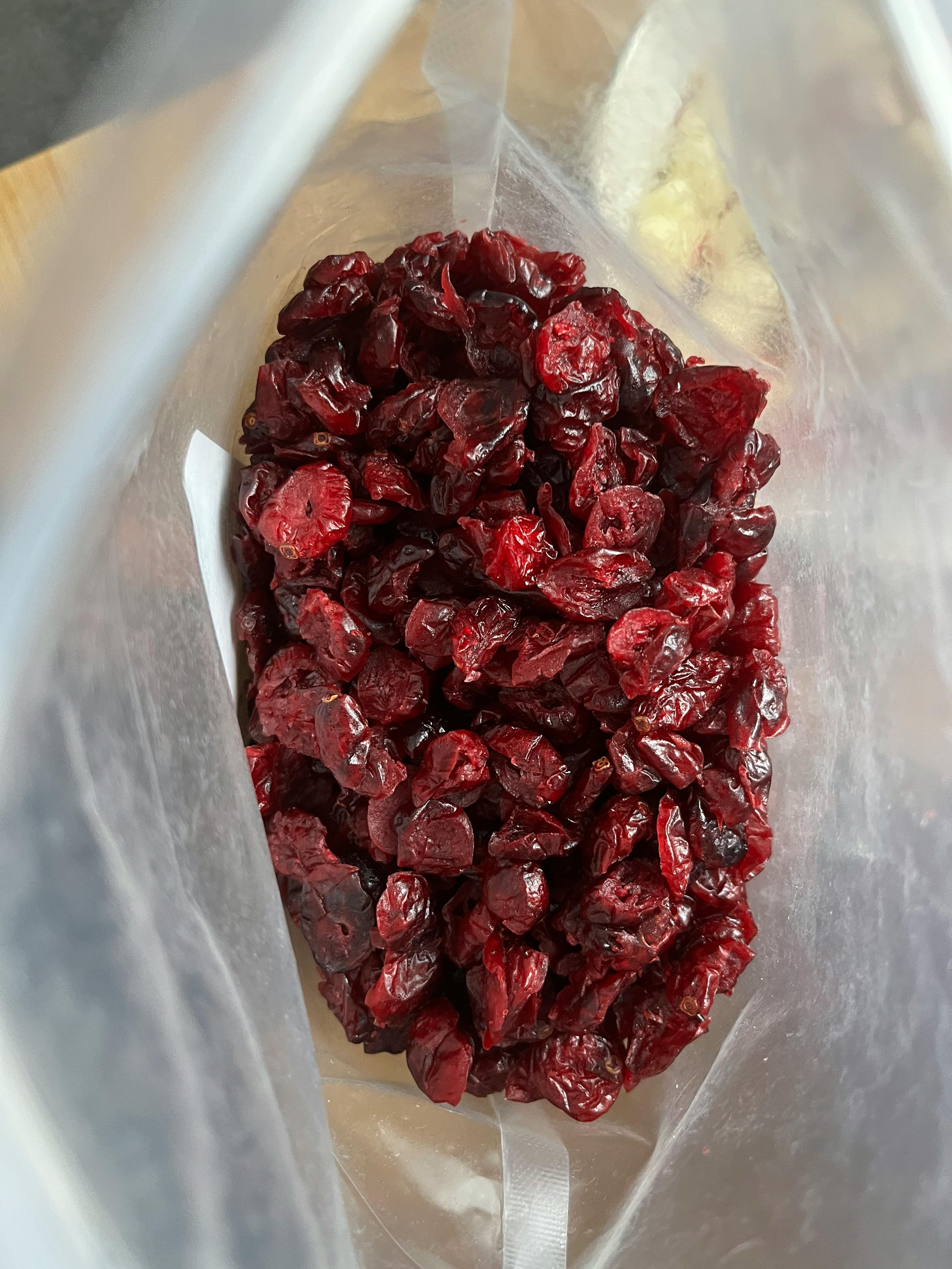 a plastic bag filled with dried cranberries on a table