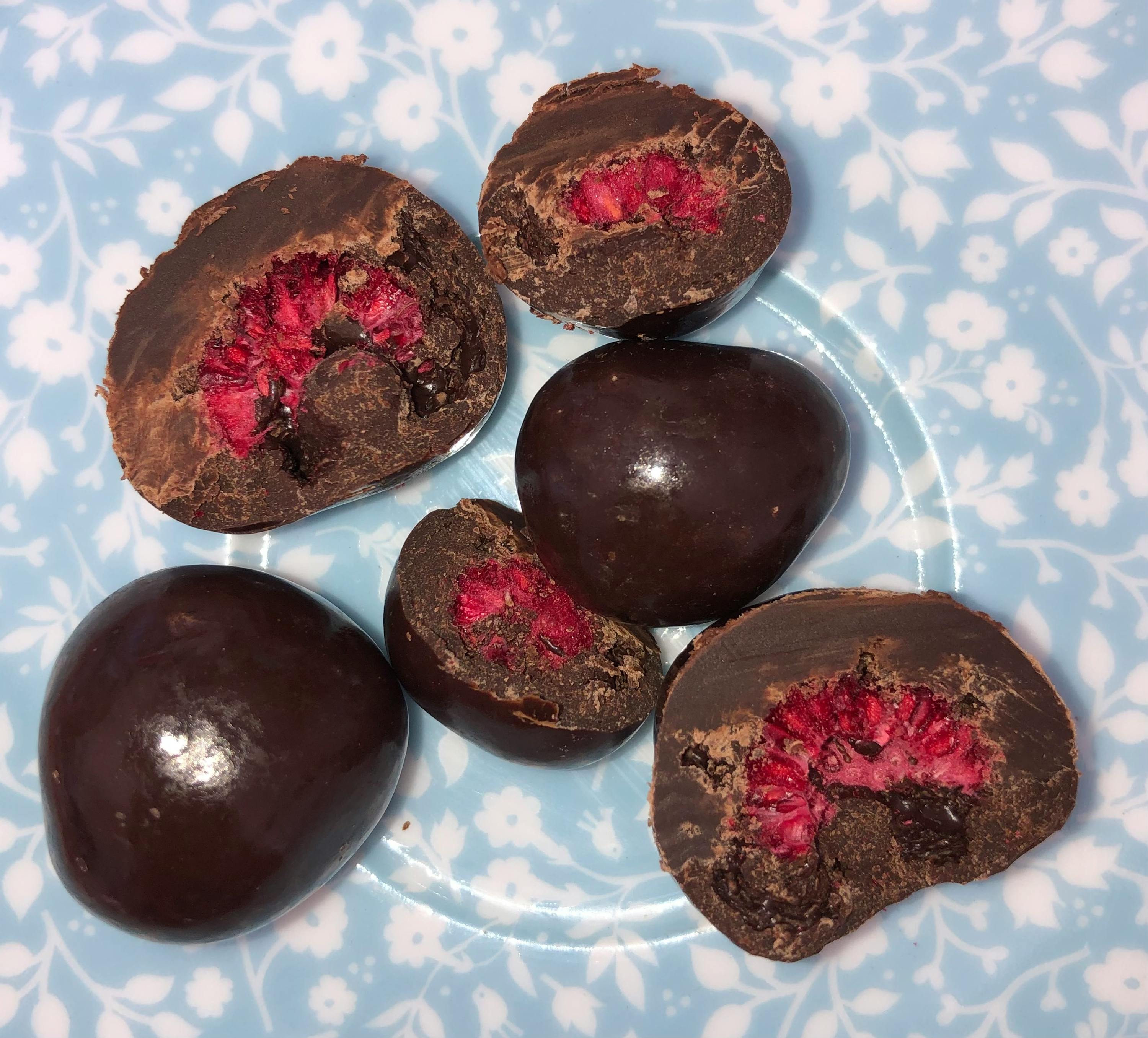 eine Reihe von Schokoladenbonbons auf einem blauen Blumenteller