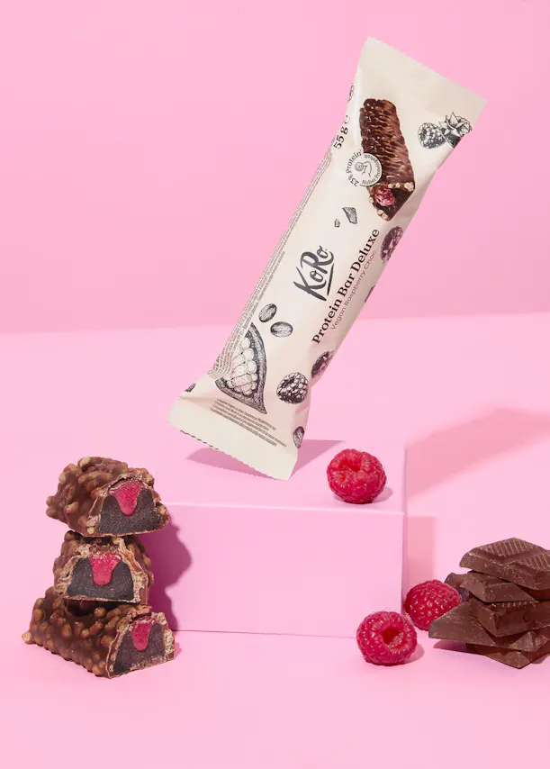 a raspberry protein bar is being displayed on a pink surface