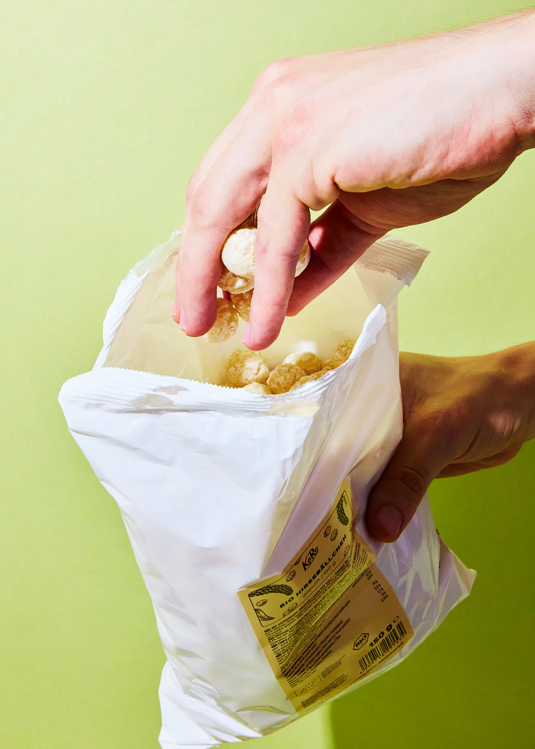 une personne tient un sac de popcorn avec une étiquette jaune