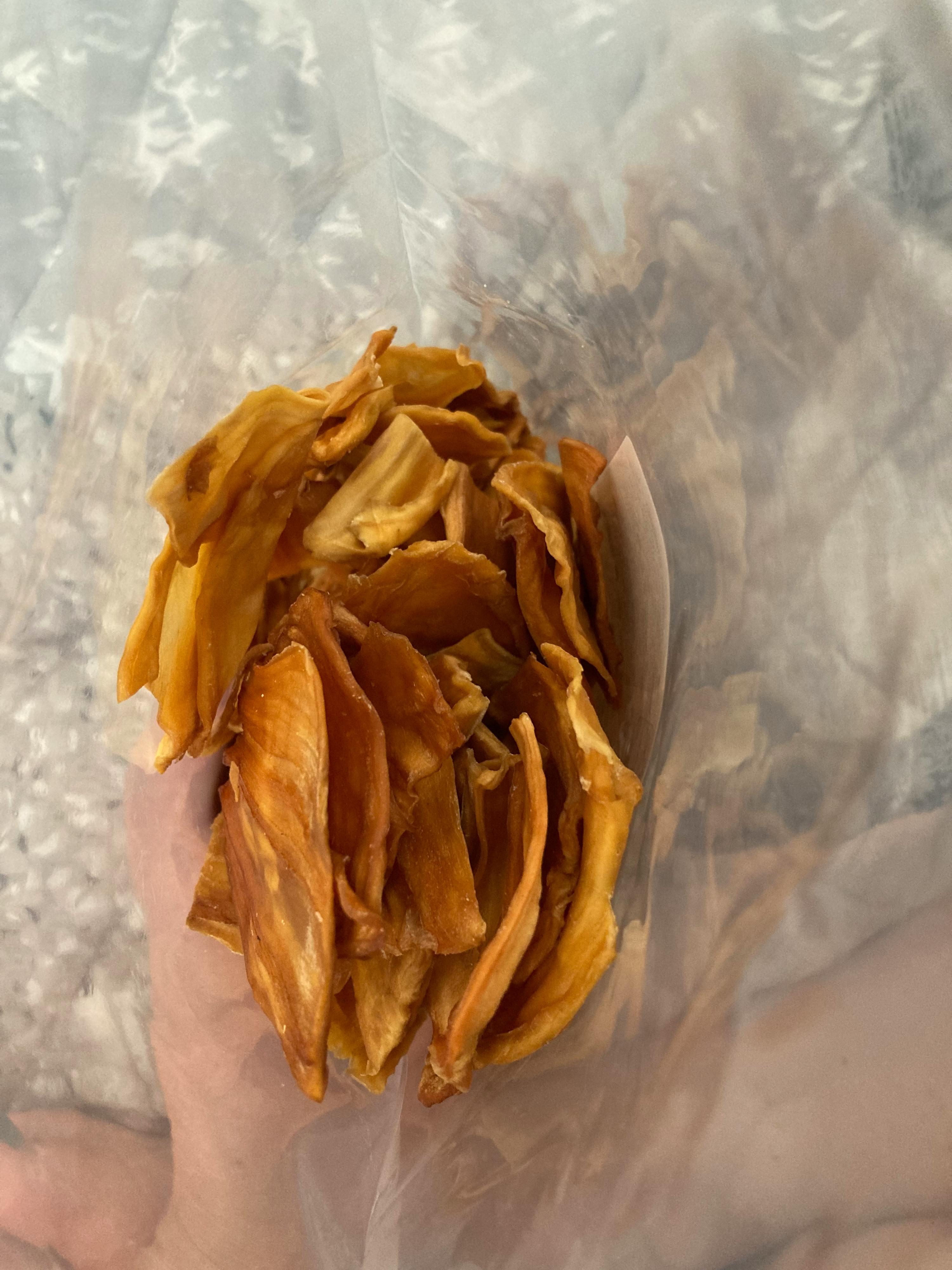 eine Person hält einen Plastikbeutel mit getrockneten Früchten in der Hand