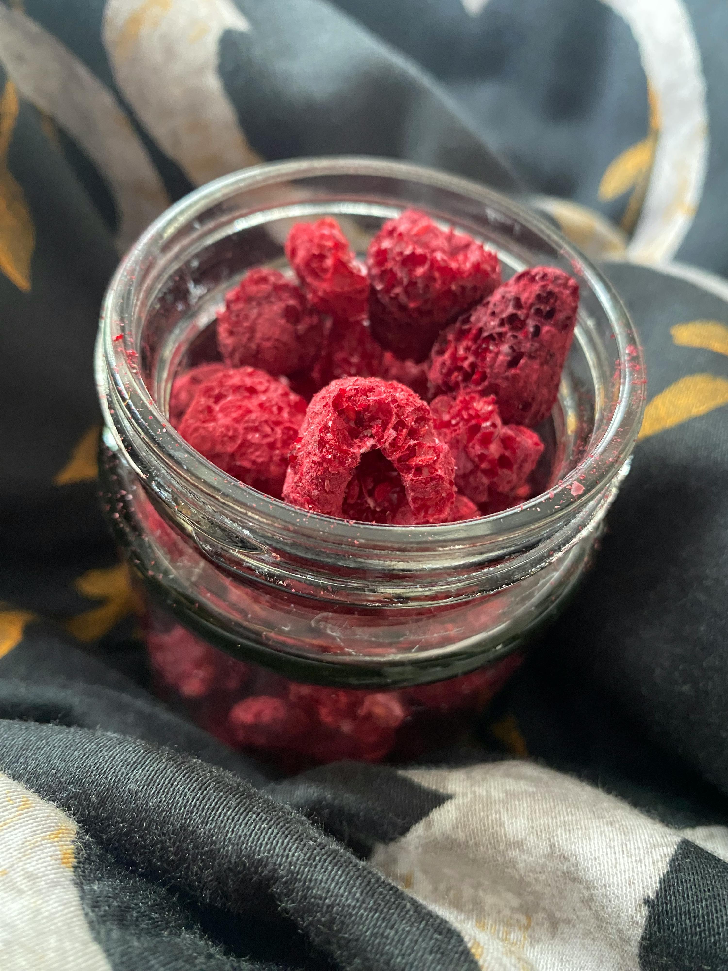 un barattolo di vetro pieno di lamponi essiccati