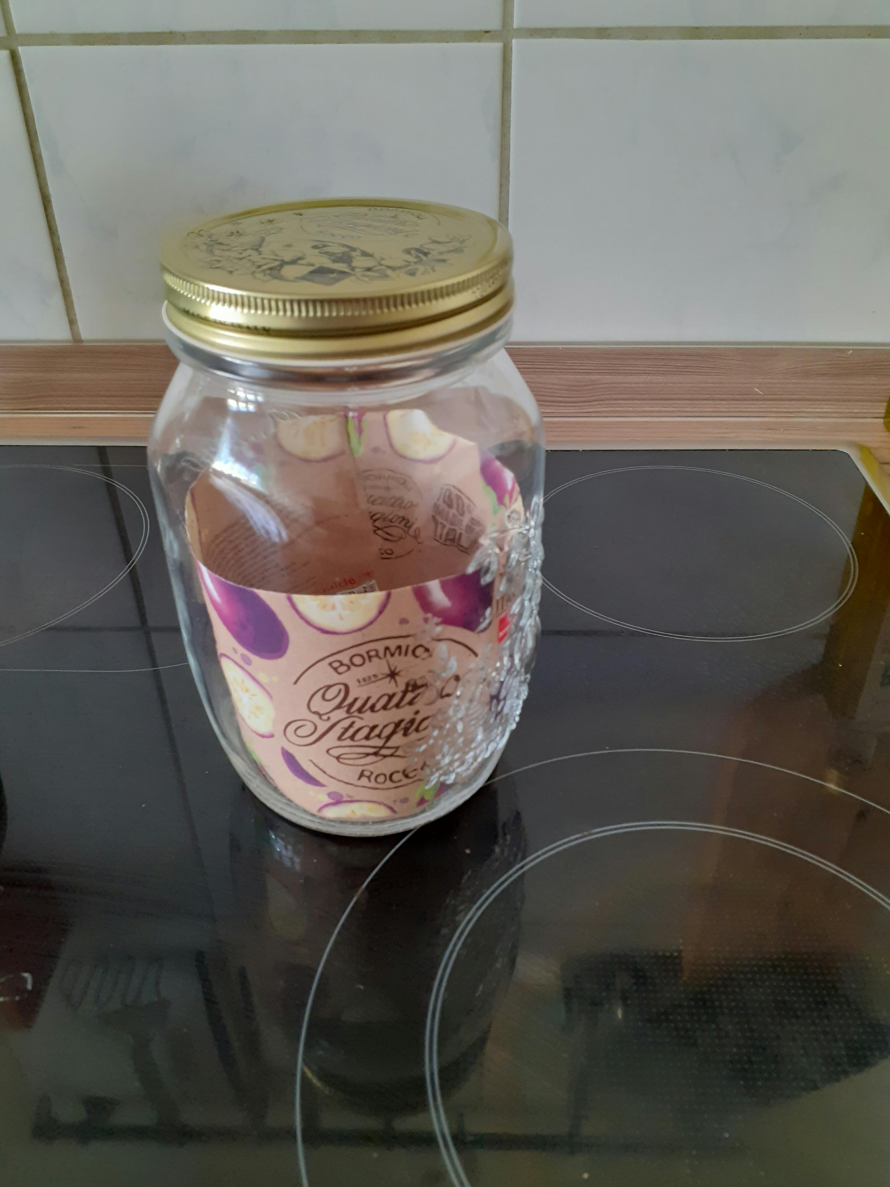 ein Glasgefäß auf einem Herd mit der Aufschrift " purple plums " darauf