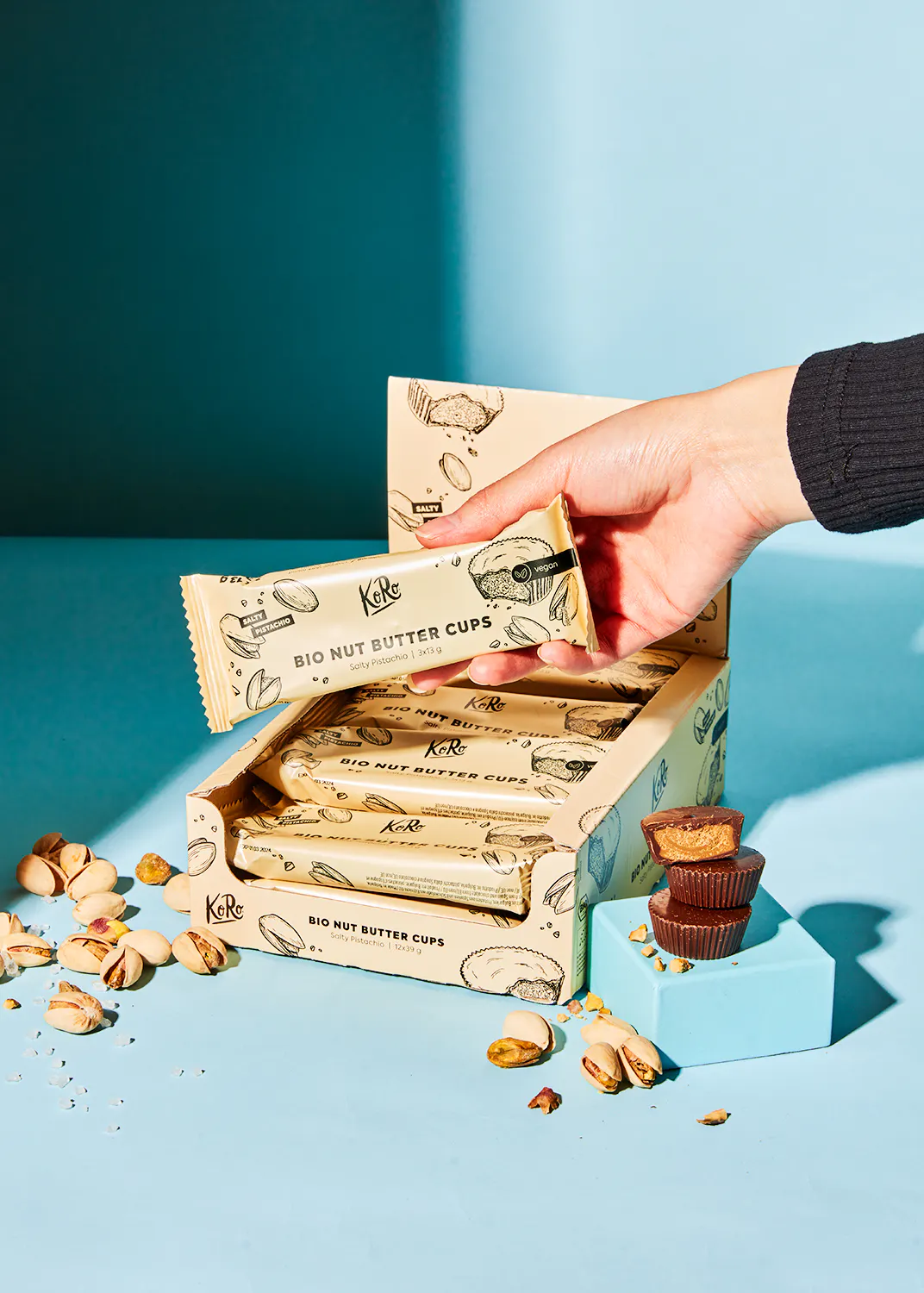 une personne tient un paquet de tasses au beurre de noix bio