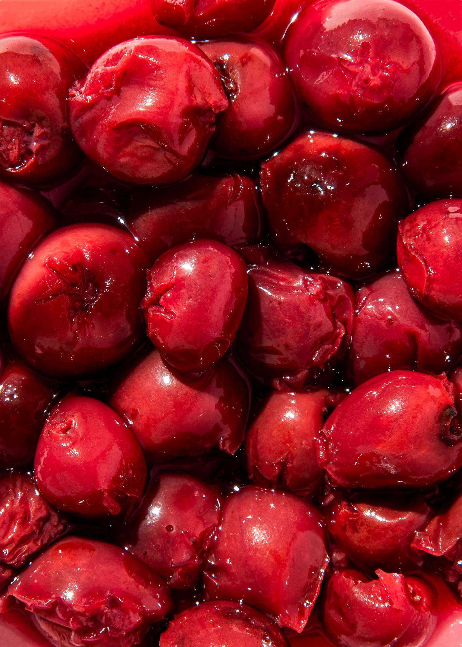 a close up of a bowl of cherries in a red liquid