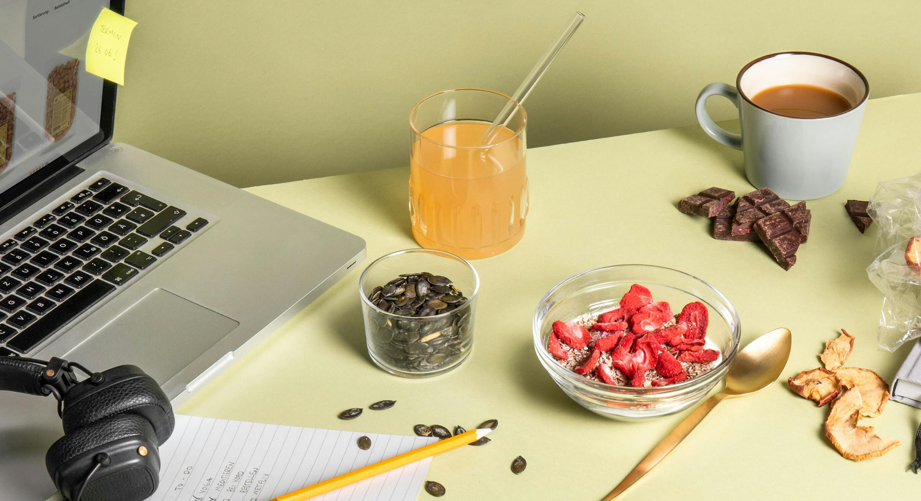 una tazza di caffè è seduta accanto a un computer portatile