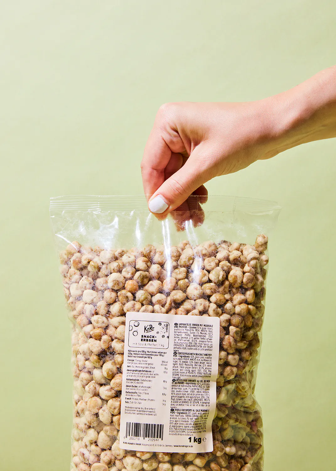 eine Person hält einen Plastikbeutel mit Erdnüssen in der Hand