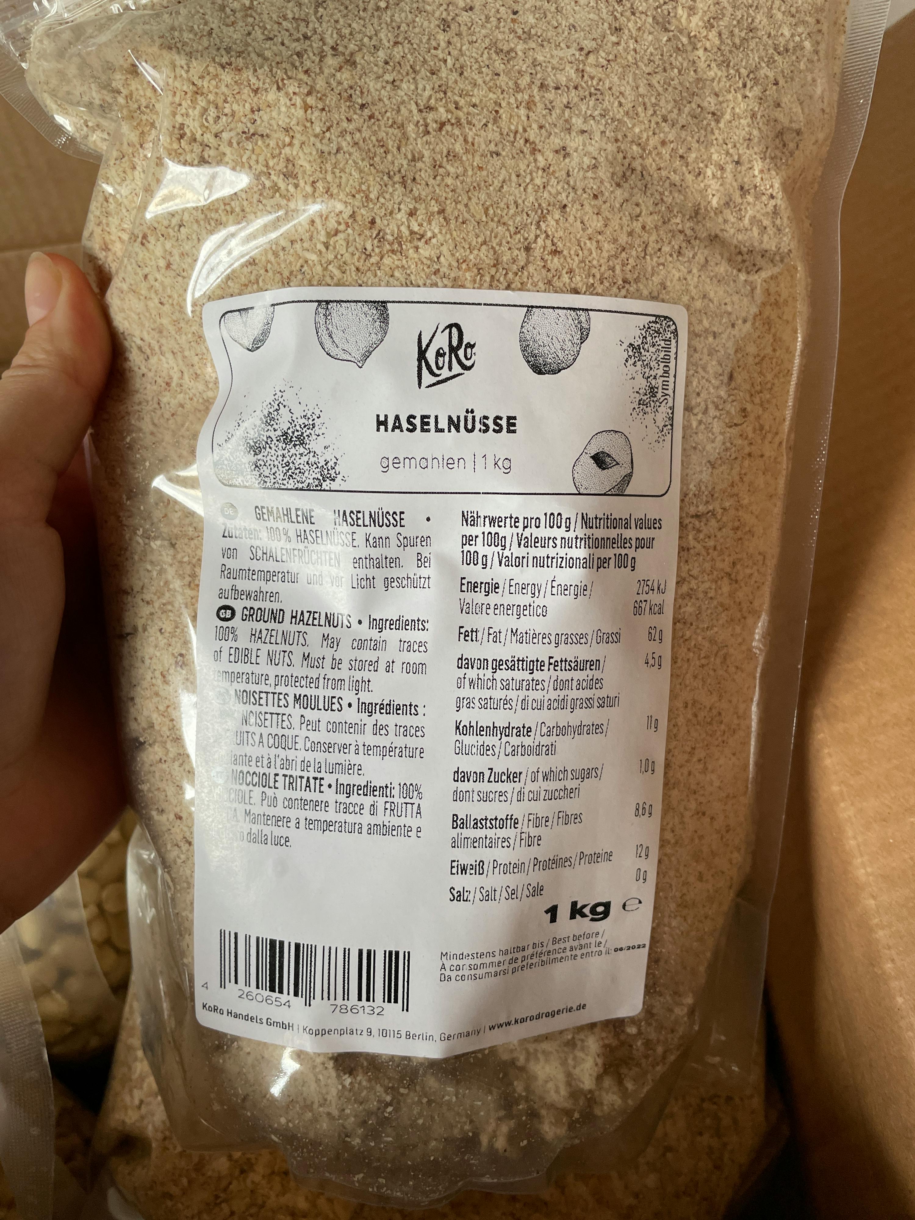 a person is holding a bag of hazelnuts that is 1 kg