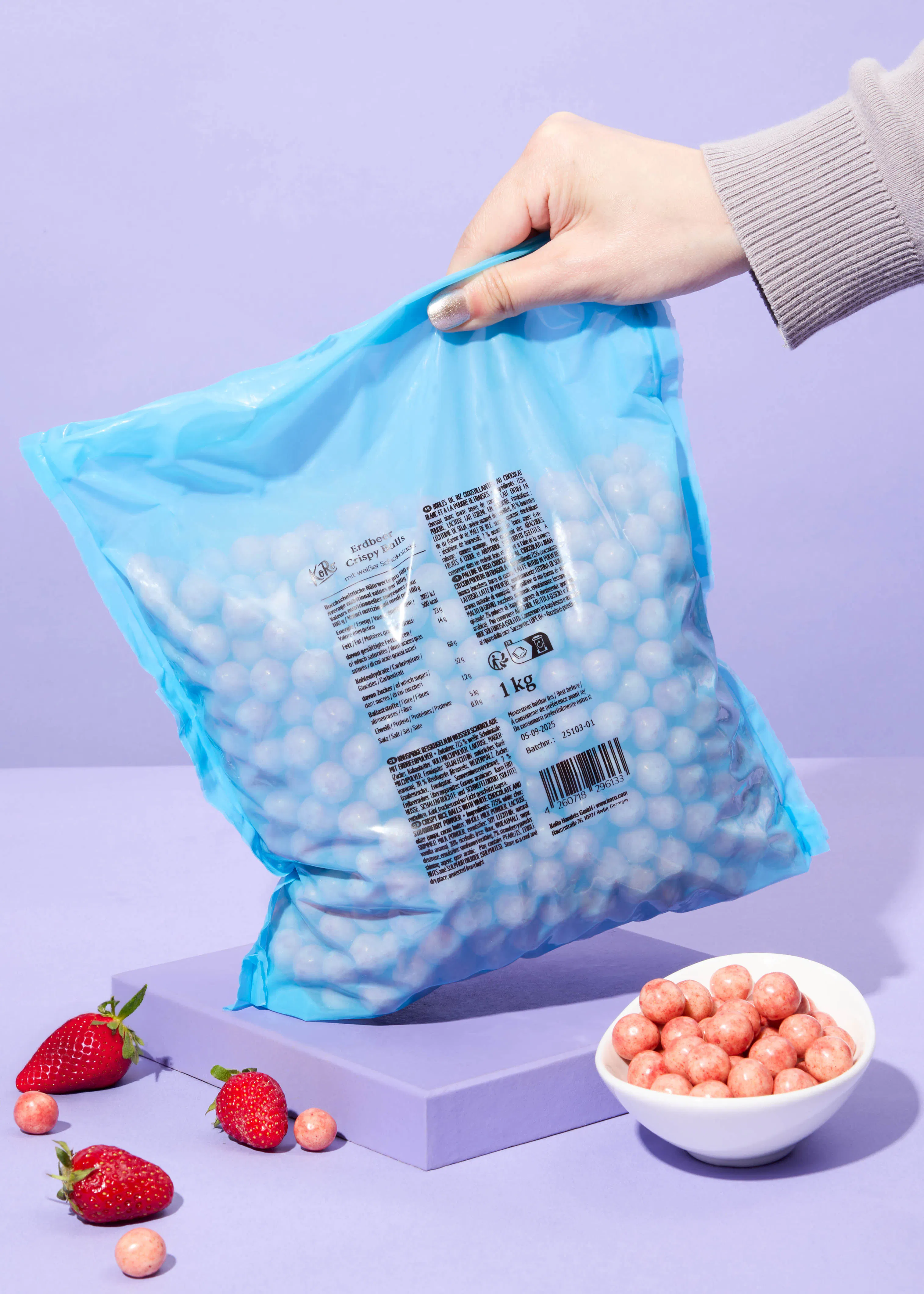 une personne tient un sac de bonbons à la fraise à côté d' un bol de bonbons