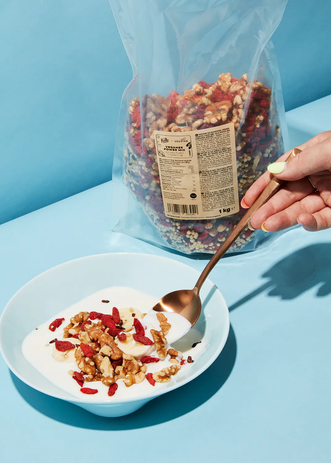 a bag of granola sits next to a bowl of yogurt