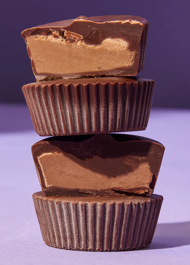 quatre tasses de beurre de cacahuète sont empilées les unes sur les autres