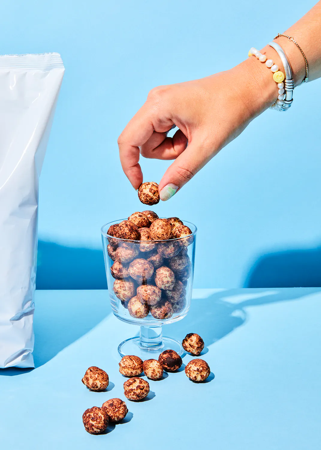 une main tient un morceau de nourriture dans un verre