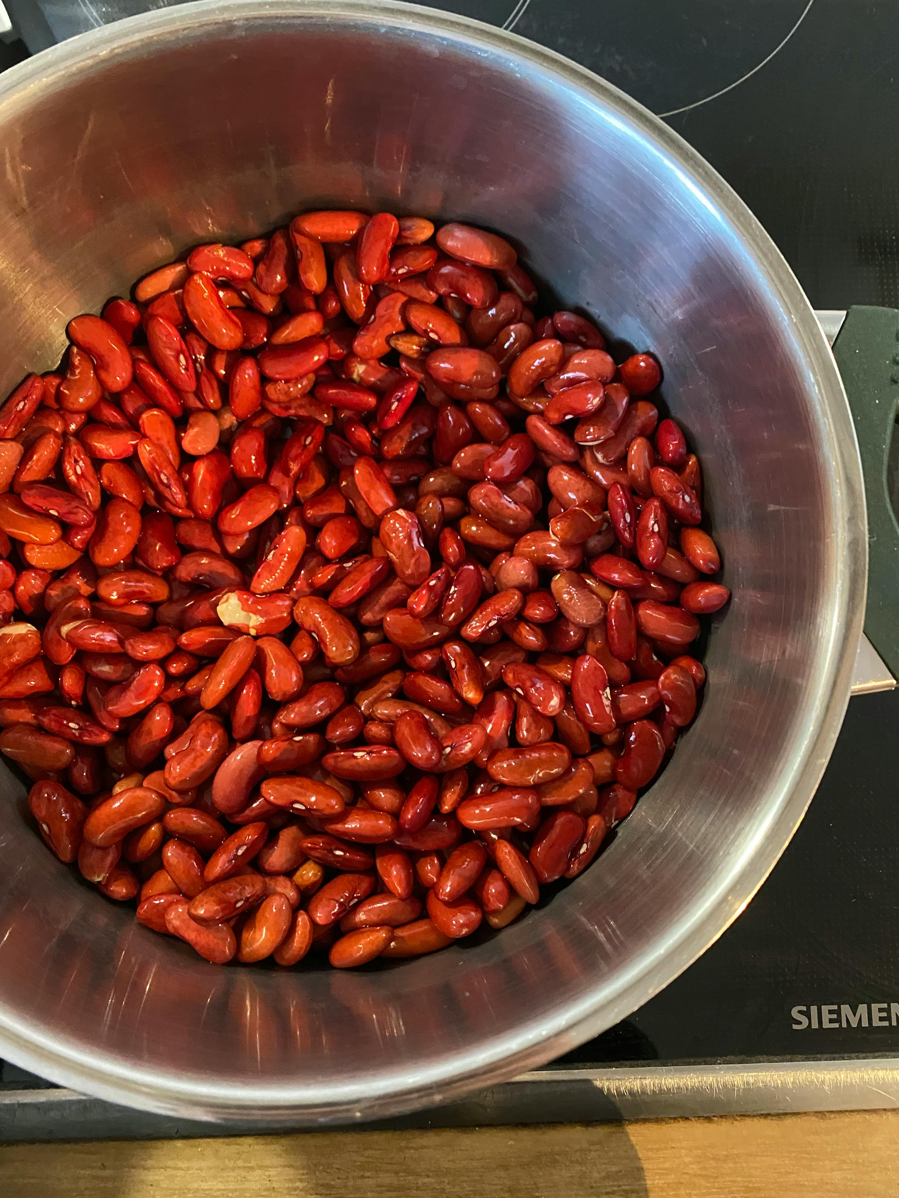 a bowl of red beans sits on a siemens stove top